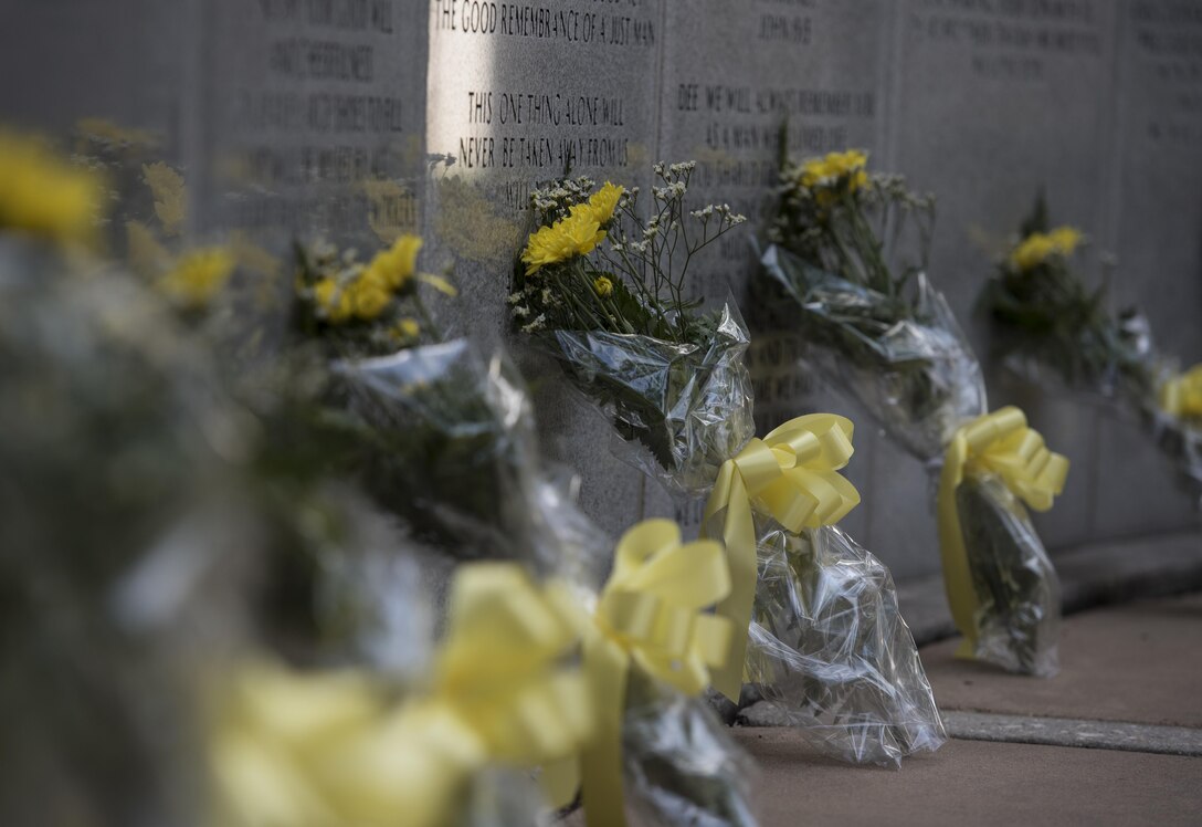 Flowers are placed along the Nomad Memorial remembrance wall for the Khobar Towers 21st Anniversary Wreath Laying Ceremony June 23, 2017, at Eglin Air Force Base, Florida. On June 25, 1996, a bomb was detonated near the Khobar Towers housing complex in Dhahran, Saudi Arabia. Nineteen Airmen were killed and more than 400 U.S. and international military and civilians were injured in the blast.  Of the 19 killed, 12 were Nomads.  Each year the 33 FW holds a ceremony in remembrance of that day. (U.S. Air Force photo by Staff Sgt. Peter Thompson)