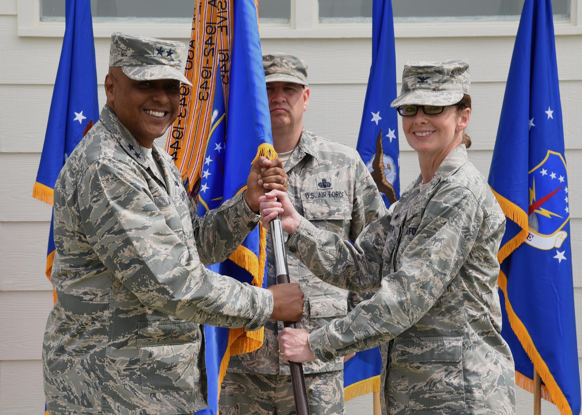 Major General Anthony Cotton, 20th Air Force Commander, passes the guidon to Col. Stacy Huser, 90th Missile Wing commander, during the change of command ceremony on the Argonne Parade Field at F.E. Warren Air Force Base, Wyo., June 23, 2017. The ceremony signified the transition of command from Col. Stephen Kravitsky to Huser. (U.S. Air Force photo by Glenn S. Robertson)