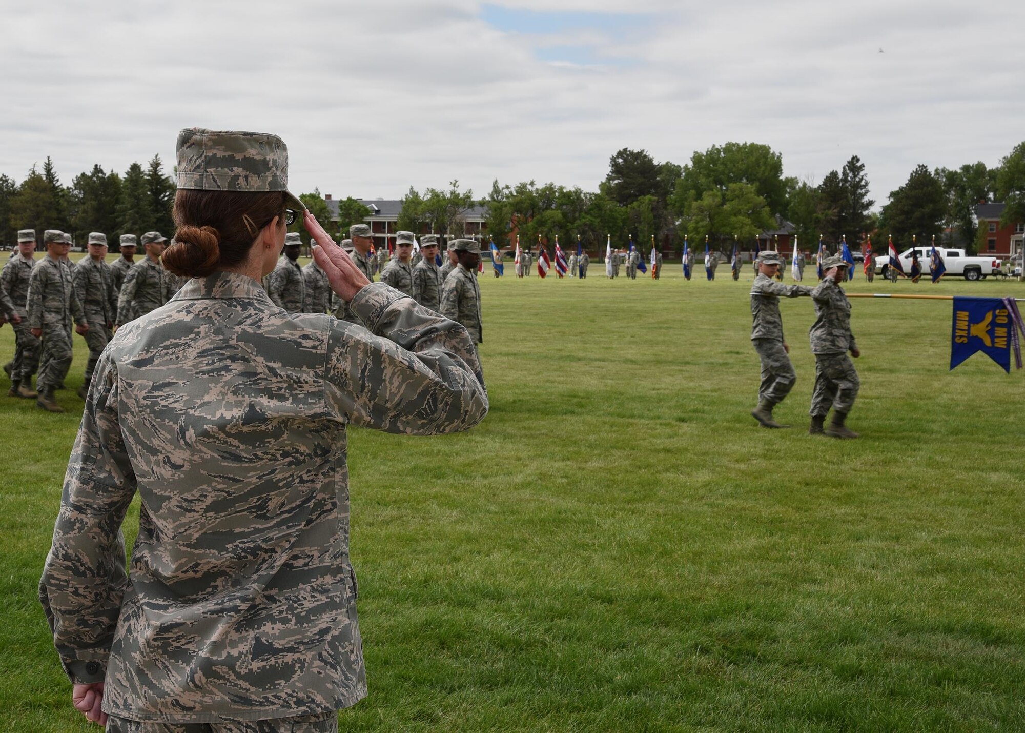 Colonel Stacy Huser, 90th Missile Wing commander, returns the salute to Airmen from the 90th Missile Maintenance Squadron marching during the Pass in Review at the change of command ceremony on the Argonne Parade Field at F.E. Warren Air Force Base, Wyo., June 23, 2017. The pass in review is a long-standing military tradition that began as a way for a newly assigned commander to inspect his troops. (U.S. Air Force photo by Glenn S. Robertson)