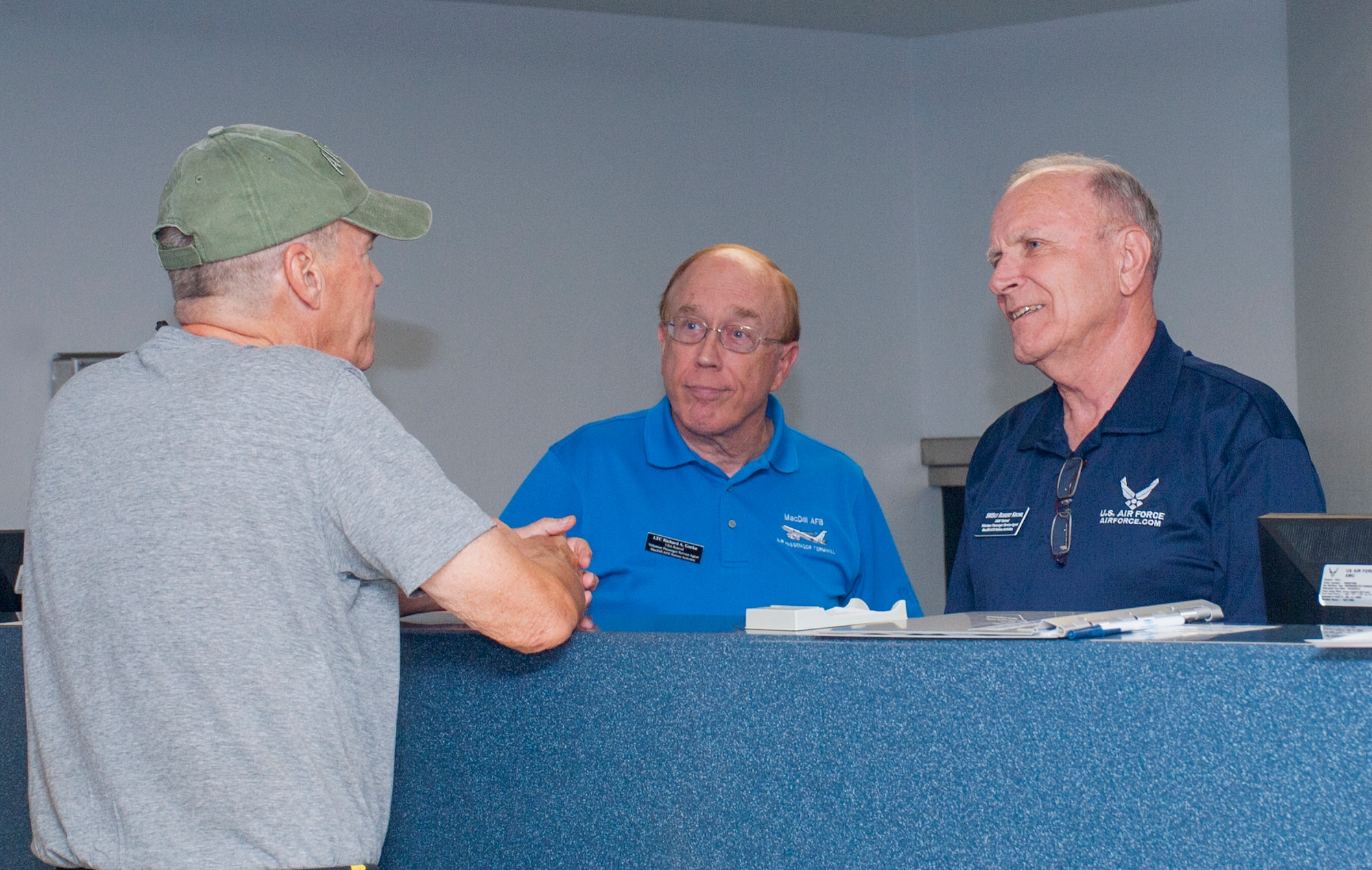Retired U.S. Army Lt. Col Richard Gorka, center, and retired U.S. Air Force Senior Master Sgt. Robert Krowl, right, both volunteers at the passenger terminal, assist a customer in the passenger terminal at MacDill Air Force Base, Fla., June 21, 2017. The passenger terminal has 16 volunteer veterans who assist with customer service.  (U.S. Air Force photo by Airman 1st Class Mariette Adams)
