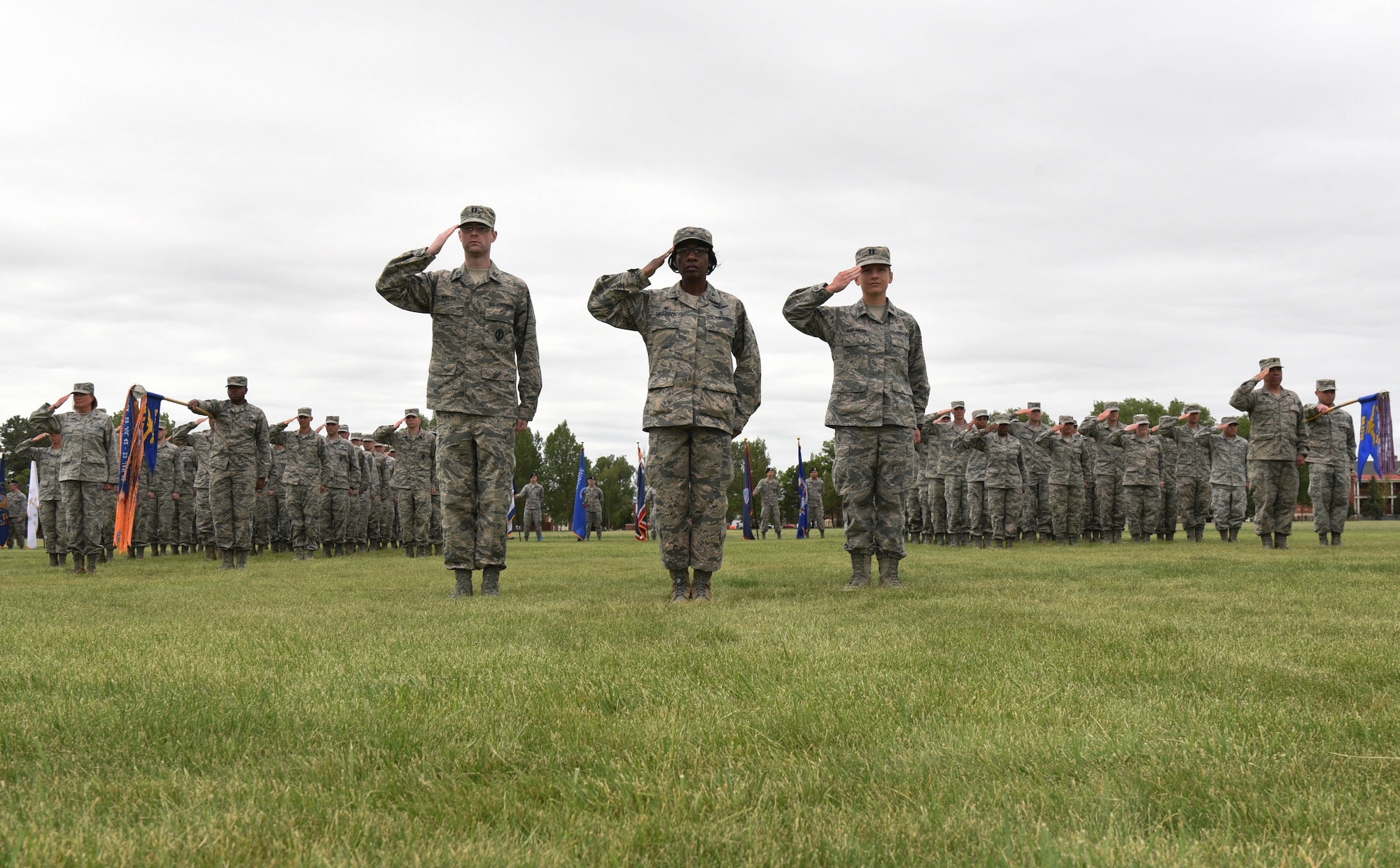 Airmen with the 90th Medical Group and the 90th Operations Group render a salute on the parade field during a change of command ceremony at F.E. Warren Air Force Base, Wyo., June 23, 2017. Col. Stacy Huser assumed command of the 90th Missile Wing during the ceremony. (U.S. Air Force photo by Airman 1st Class Breanna Carter)