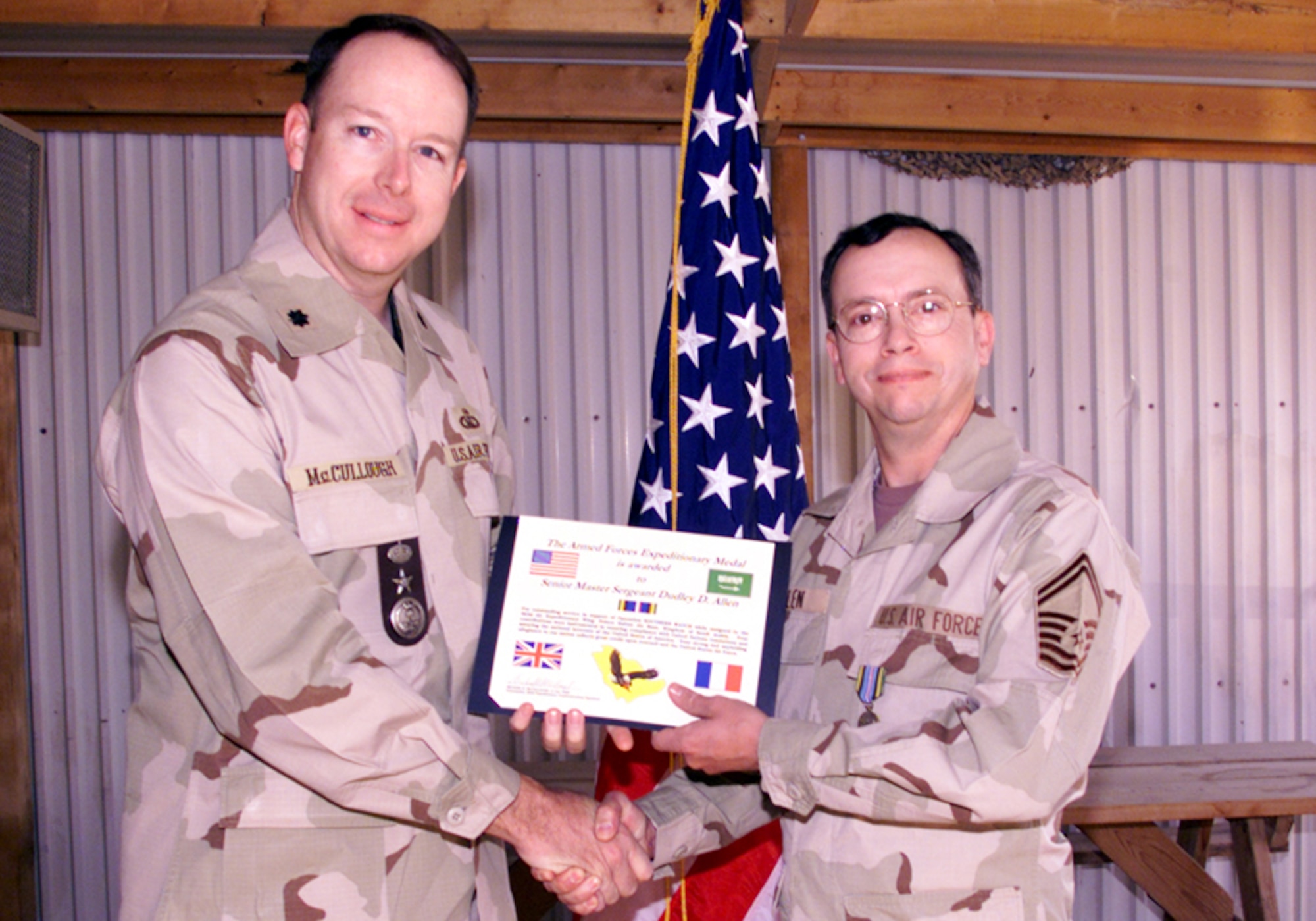 Lt. Col. McCullough presents Senior Master Sgt. Dudley Allen with an Armed Forces Expeditionary Medal certificate for his achievements during Operation Southern Watch in 2000.