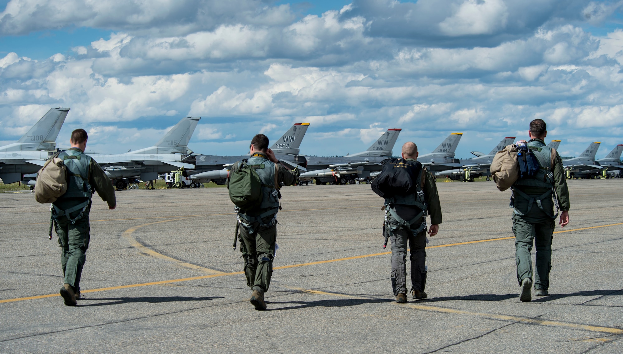 U.S. Air Force fighter pilots assigned to the 14th Fighter Squadron walk onto the flight line during RED FLAG-Alaska 17-2 June 16, 2017, at Eielson Air Force Base, Alaska. RED FLAG-Alaska provides an optimal training environment in the Indo-Asia Pacific Region and focuses on improving ground, space, and cyberspace combat readiness and interoperability for U.S. and international forces.  (U.S. Air Force photo by Airman 1st Class Haley D. Phillips)