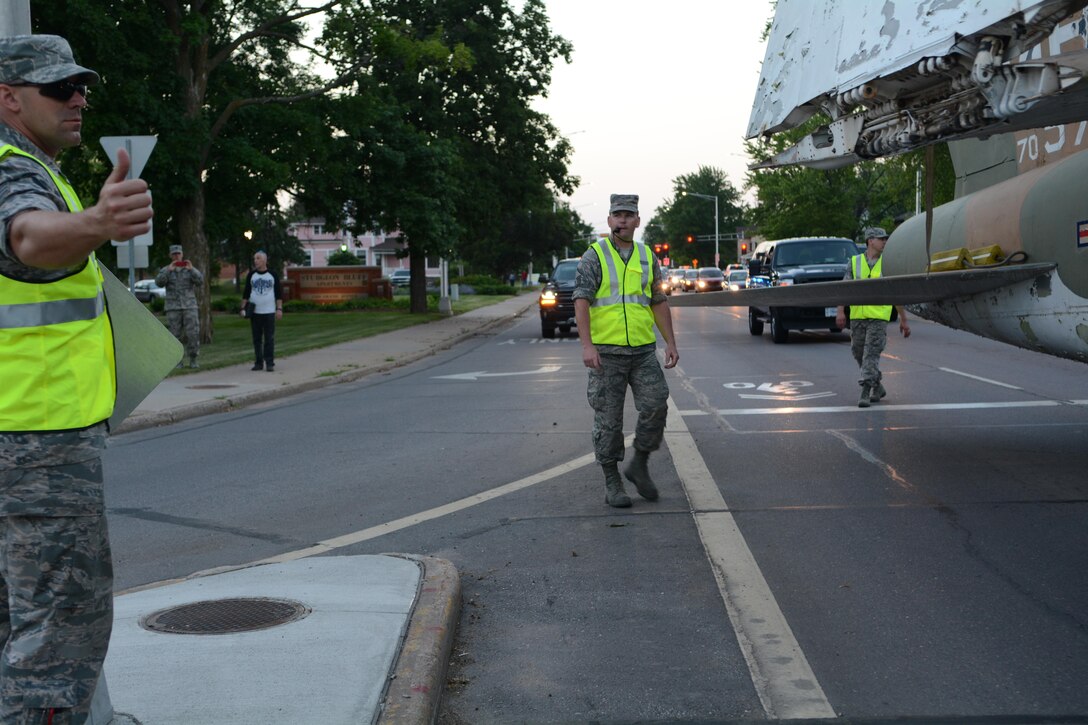 Members of the 115th Fighter Wing Crash, Disaster or Disabled Aircraft Recovery Team in coordination with Wausau city officials, police and city workers move a 1969 A-7 Corsair II aircraft through the streets of Wausau behind a 1966 John Deere 4020 tractor June 13, 2017 in Wausau, Wis. 
