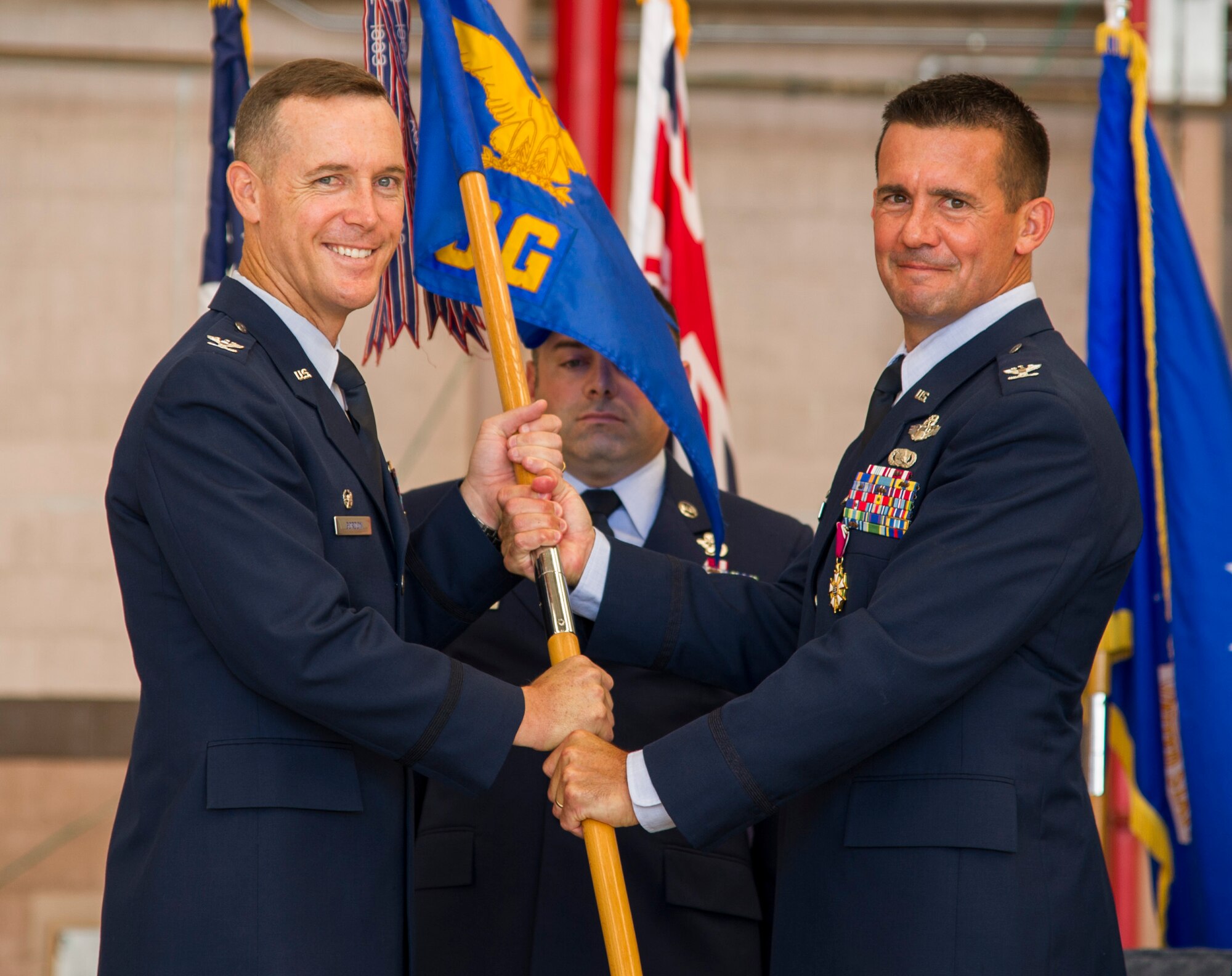 Col. Kevin Gordon, 15th Wing commander, takes the group flag from Col. Charles Velino, 15th Operations Group commander, during the 15th Operations Group Change of Command Ceremony, Joint Base Pearl Harbor-Hickam, Hawaii, June 22, 2017. The 15th Operations Group oversees operations at the largest joint-use airflield in the U.S., executes global combat and peace time operations, and provides executive airlift for senior military leaders.  (U.S. photo by Tech. Sgt. Heather Redman)