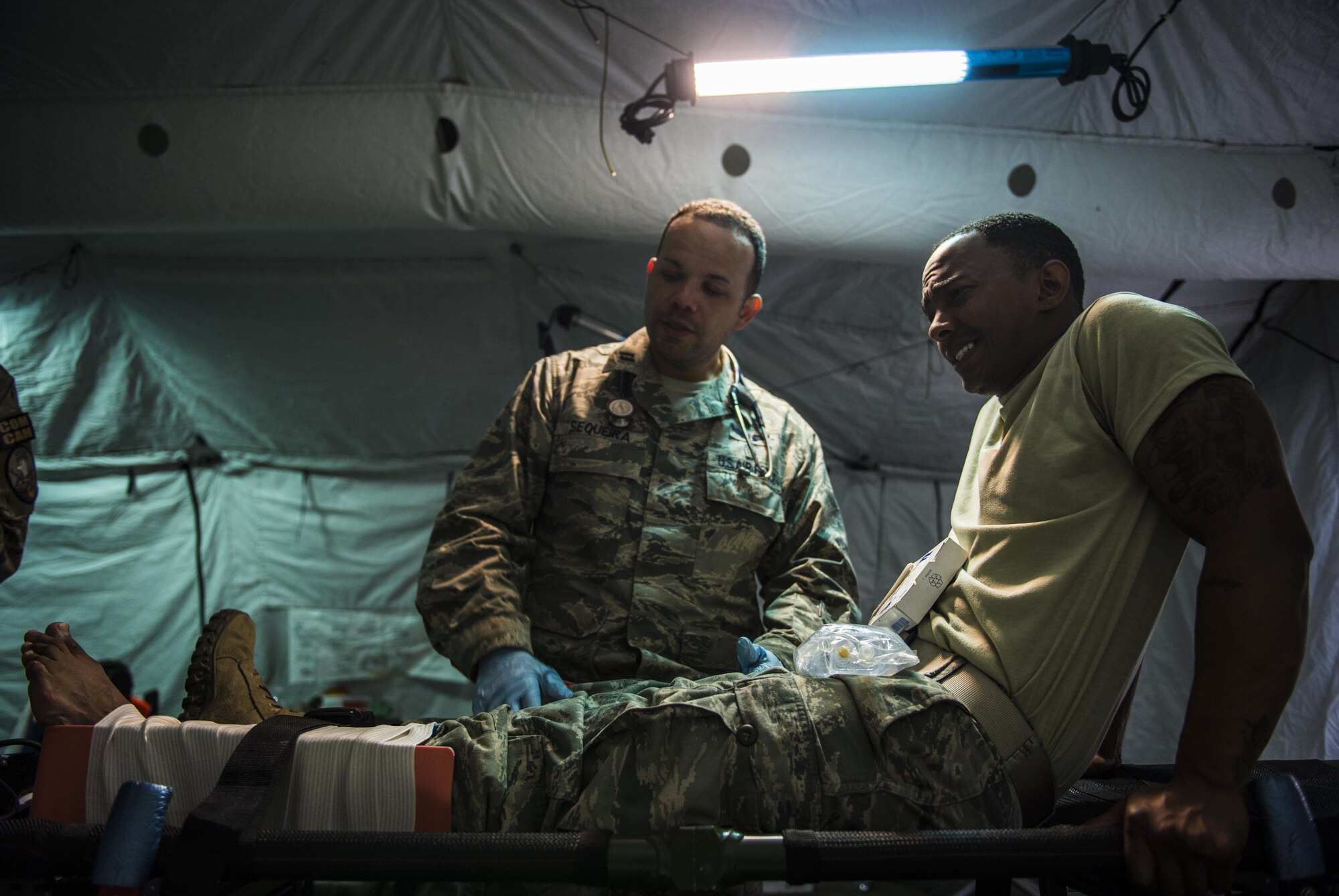 Capt. Ricardo Sequeira, left, an 821st Contingency Response Squadron flight medicine provider, discusses his medical procedures for a lower leg trauma with Staff Sgt. Zachary Green, Headquarters Air Mobility Command, standardization and evaluation, during a medical exercise at Battle Creek Air National Guard Base, Mich., June 11, 2017. Turbo Distribution 17-2 is a U.S. Transportation Command exercise designed to assess the Joint Task Force-Port Opening’s ability to deliver and distribute cargo during humanitarian and disaster relief operations. (U.S. Air Force photo/Senior Airman Xavier Navarro)