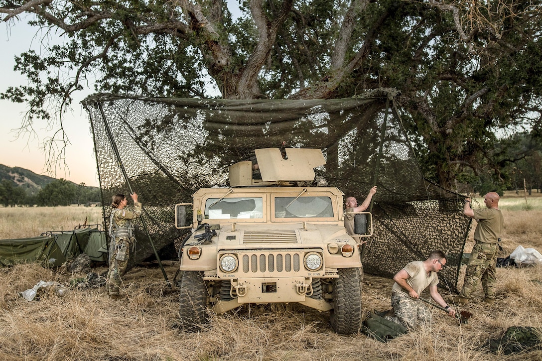 Soldiers assemble a camouflage netting system to provide concealment and shade during an exercise at Fort Hunter Liggett, Calif., June 19, 2017. The soldiers are reservists assigned to the 339th Military Police Company, based in Davenport, Iowa. Army photo by Master Sgt. Michel Sauret