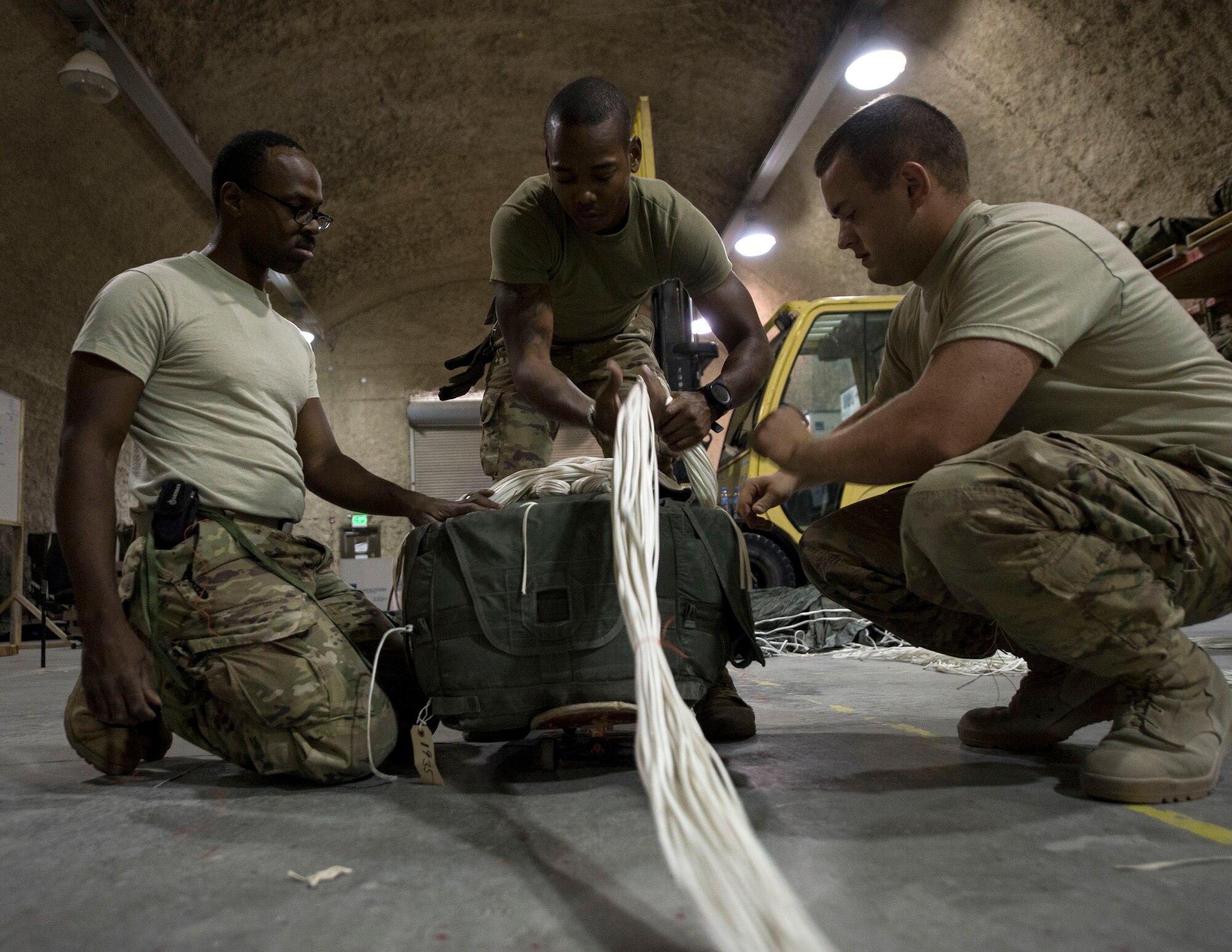 U.S. Army Soldiers with the 824th Quartermaster Company Detachment 2 place suspension lines on top of a joint precision airdrop system at Al Udeid Air Base, Qatar, May 31, 2017. The Soldiers completed an inspection of the JPADS that included, but was not limited to, cleaning and any repairs necessary on the system attached to equipment used in airdrop operations. (U.S. Air Force photo by Tech. Sgt. Amy M. Lovgren)