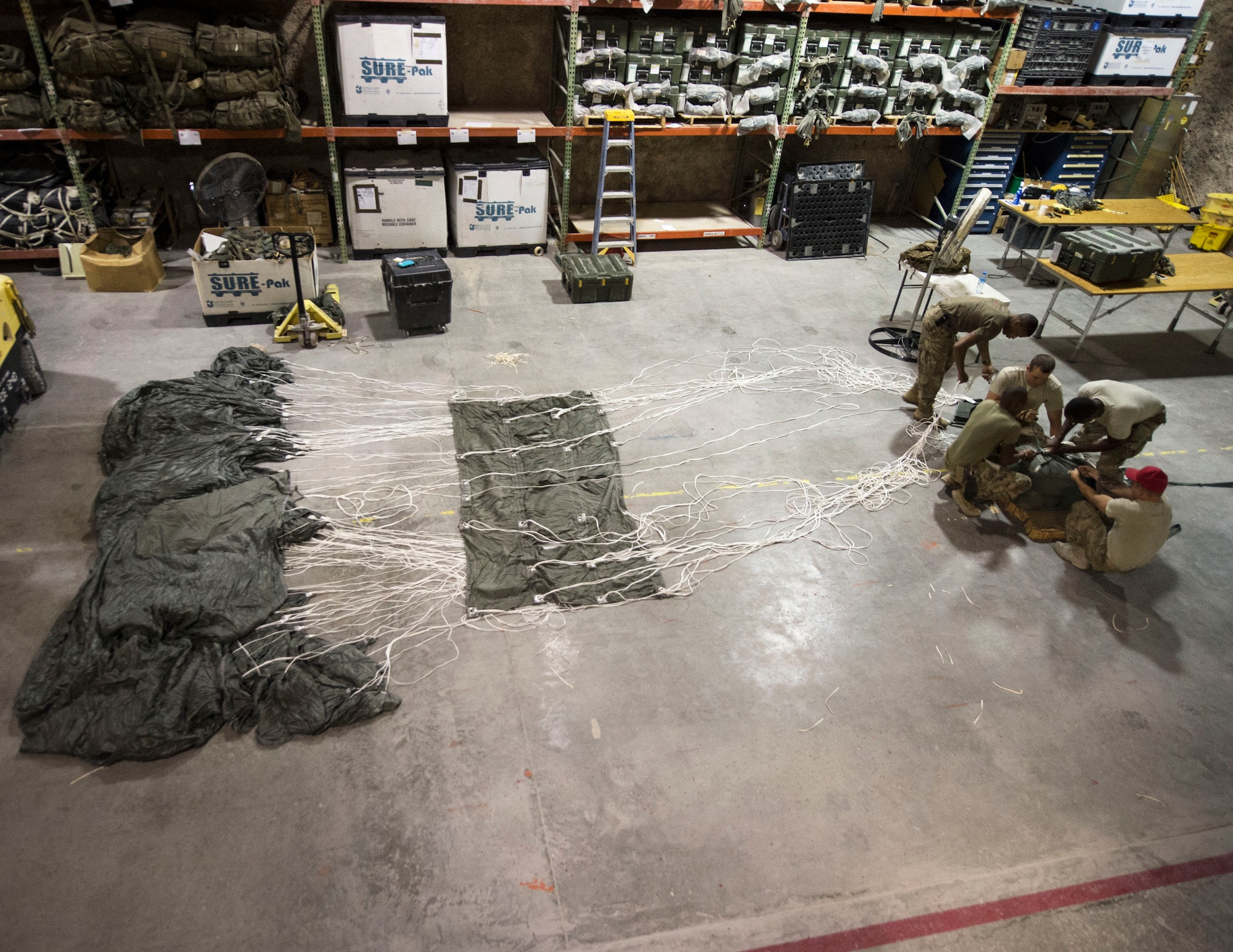 U.S. Army Soldiers with the 824th Quartermaster Company Detachment 2 prepare to pack a joint precision airdrop system at Al Udeid Air Base, Qatar, May 31, 2017. The Soldiers unpacked a JPADS in order to conduct an inspection that included, but was not limited to, cleaning and any repairs necessary on the system that is used in airdrop operations. (U.S. Air Force photo by Tech. Sgt. Amy M. Lovgren)