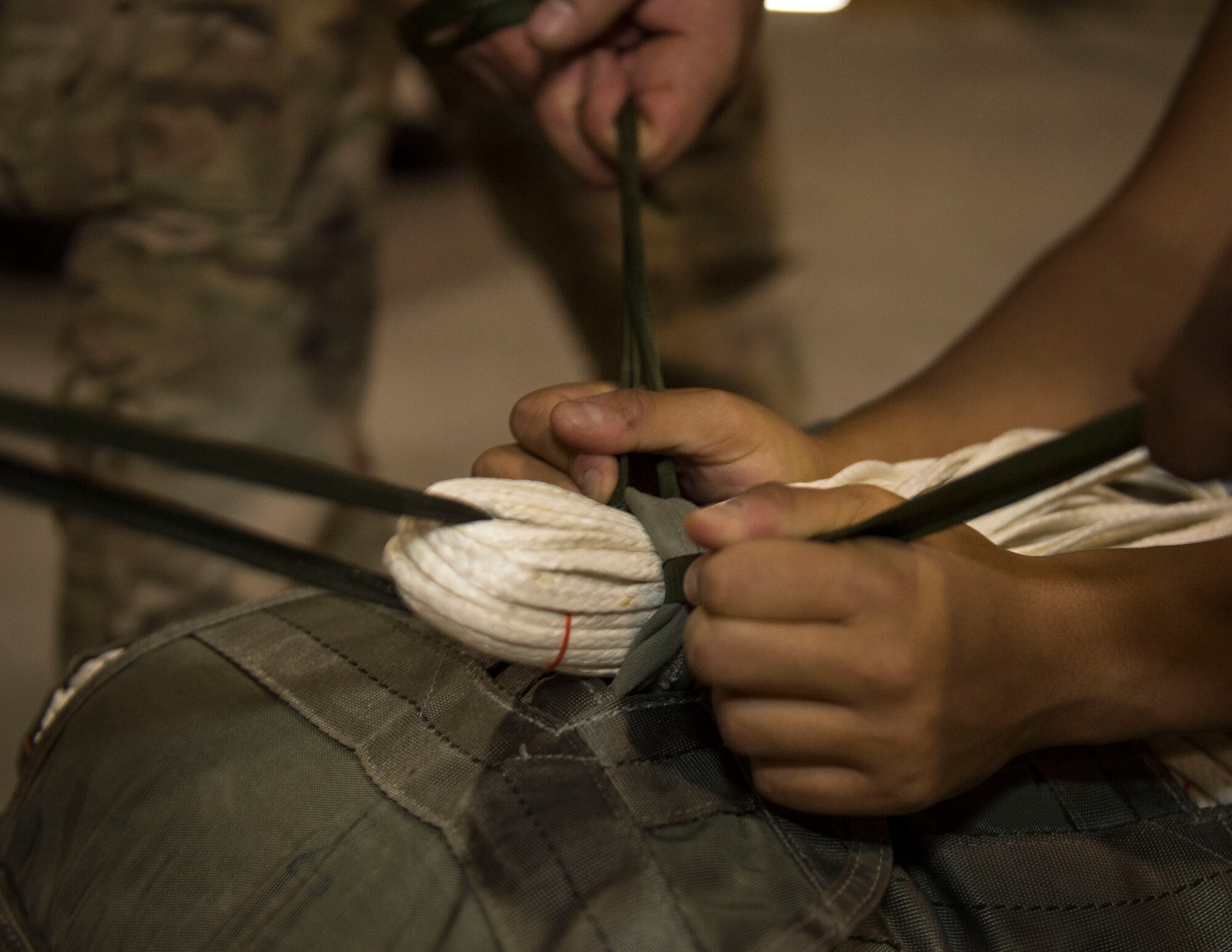 U.S. Army Soldiers with the 824th Quartermaster Company Detachment 2 pull control lines through a joint precision airdrop system at Al Udeid Air Base, Qatar, May 31, 2017. The Soldiers completed an inspection of the JPADS that included, but not was limited to, cleaning and any repairs necessary on the system attached to equipment used in airdrop operations. (U.S. Air Force photo by Tech. Sgt. Amy M. Lovgren)