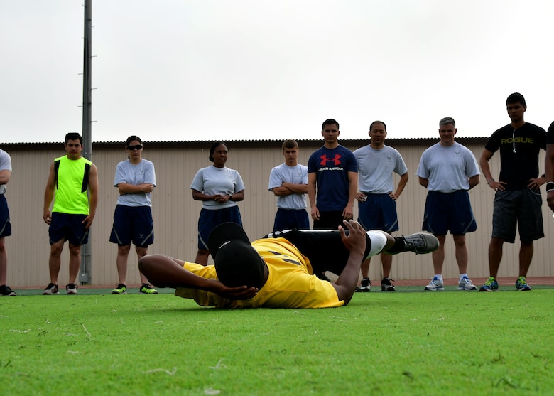 U.S. Air Force Airman 1st Class Derrick Norman, 51st Force Support Squadron fitness specialist, instructs members of Osan Air Base on how to do oblique crunches during the “Rogers Fit Workout” challenge June 23, 2017 at Osan AB, Republic of Korea. The 731st AMS along with the Osan Top Three Heritage Committee and the 51st Force Support Squadron Fitness Staff unveiled a memorial and hosted the “Rogers Fit Workout” challenge in honor of Rogers, who has passed away May 20, 2016, due to injuries she sustained from helping a family escape a burning apartment building. (U.S. Air Force photo by Senior Airman Franklin R. Ramos/Released)