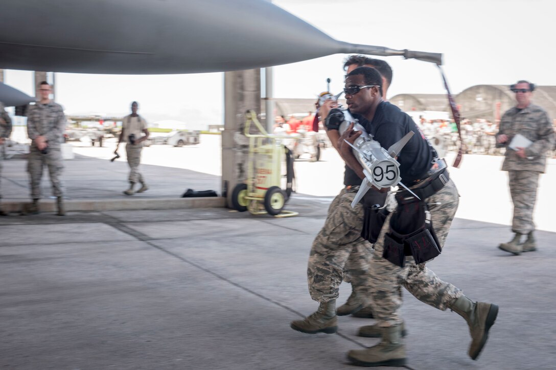 A weapons load team from the 120th Fighter Squadron carries an AIM-9 sidewinder missile toward an F-16 Fighting Falcon during a quarterly weapons load competition June 23, 2017, at Kadena Air Base, Japan. The Colorado Air National Guard, Buckley Air Force Base, is touring Kadena as part of a theater security package. (U.S. Air Force photo by Senior Airman John Linzmeier)