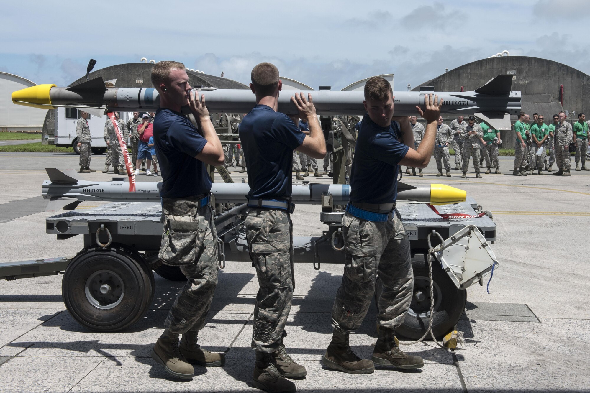 A U.S. Air Force weapons load team from the 44th Aircraft Maintenance Unit, carries an AIM-9 sidewinder missile toward an F-15 Eagle fighter aircraft during a quarterly weapons load competition June 23, 2017, at Kadena Air Base, Japan. Weapons load competitions are conducted quarterly to keep Airmen sharp and to recognize superior performers. (U.S. Air Force photo by Senior Airman John Linzmeier)