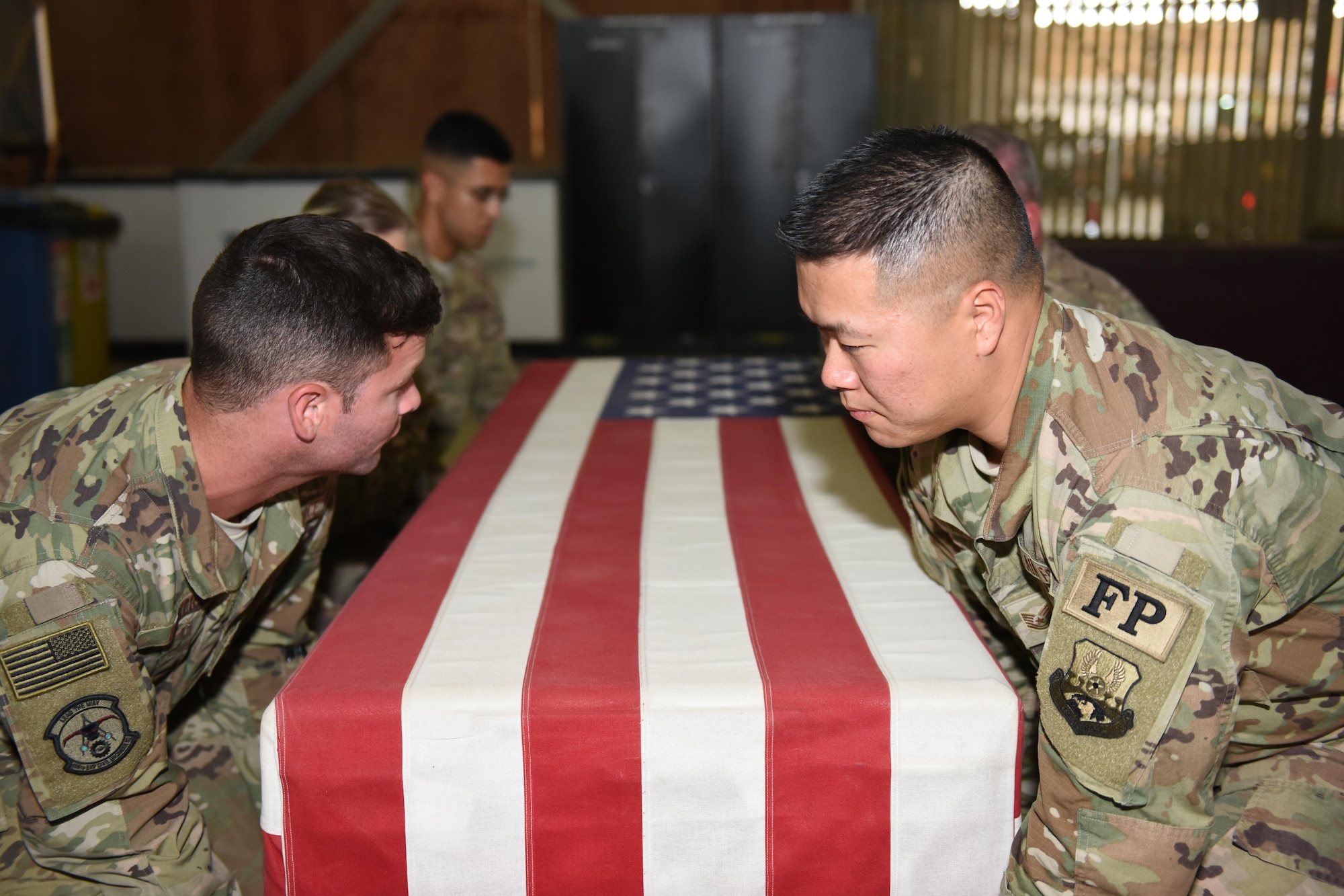 Tech. Sgt. David Yuen (right), a force protection member with the 387th Expeditionary Support Squadron, and other force protection and fire fighter members conduct a dignified transfer ceremony practice at an undisclosed location in Southwest Asia, June 22, 2017. The 387th Force Protection flight is responsible for providing dignified transfers to a theater mortuary evacuation point ran by the U.S. Army. (U.S. Air Force photo/Tech. Sgt. Jonathan Hehnly)