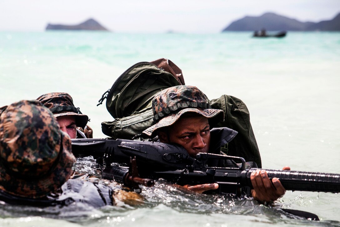 Marine Corps Lance Cpl. Armanie Singletary, right, provides security during an amphibious exercise at Marine Corps Training Area Bellows, Hawaii, June 15, 2017. Singletary is a raider reconnaissance team operator assigned to the 3rd Radio Reconnaissance Platoon, 3rd Radio Battalion. Marine Corps photo by Lance Cpl. Luke Kuennen