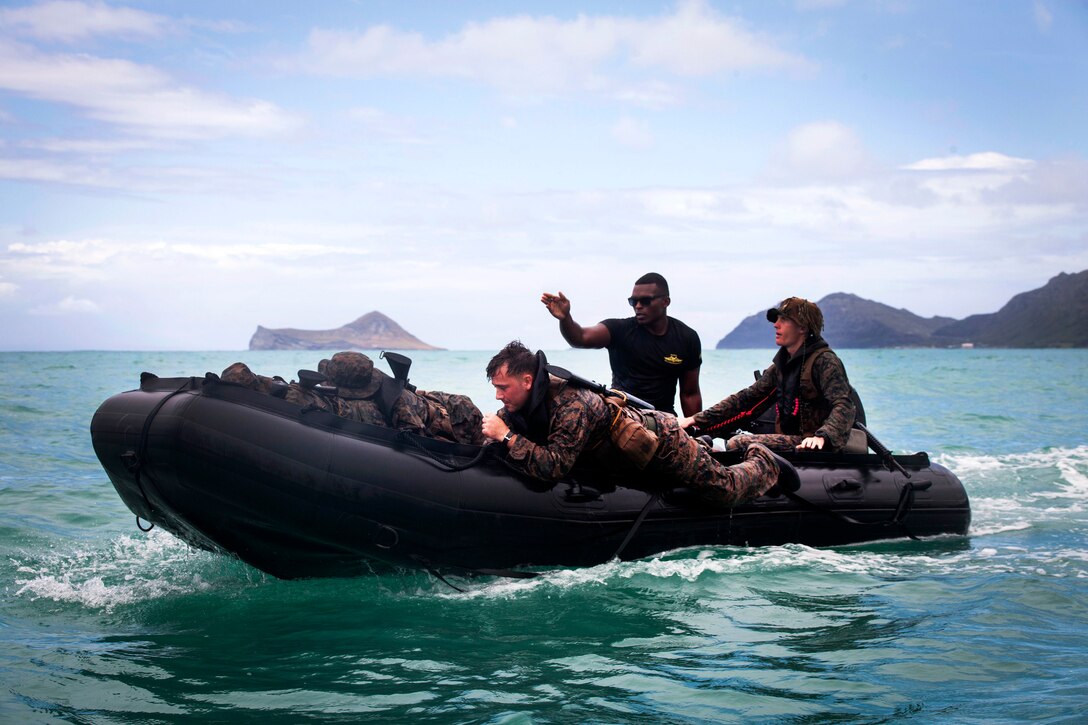 Marine Corps Sgt. Antuan D. Martin, center, instructs Marines during an amphibious exercise at Marine Corps Training Area Bellows, Hawaii, June 15, 2017. Martin is the lead instructor of Raider Reconnaissance Operator Course. He demonstrated how to safely launch and beach a Zodiac inflatable craft with several surf passage exercises. Marine Corps photo by Lance Cpl. Luke Kuennen