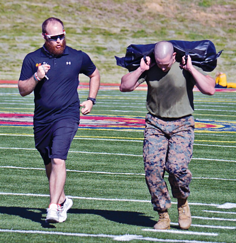 High Intensity Tactical Training Charles Yackle pushes Staff Sgt. Christopher Ramsey past the point of comfort in his preliminary trials. As the Marine fends against 90 degree heat during the fireman's carry with a sandbag across all 100-yards of Butler Stadium, his only motivation in reaching the endzone are the squats he will endure with the same weight.