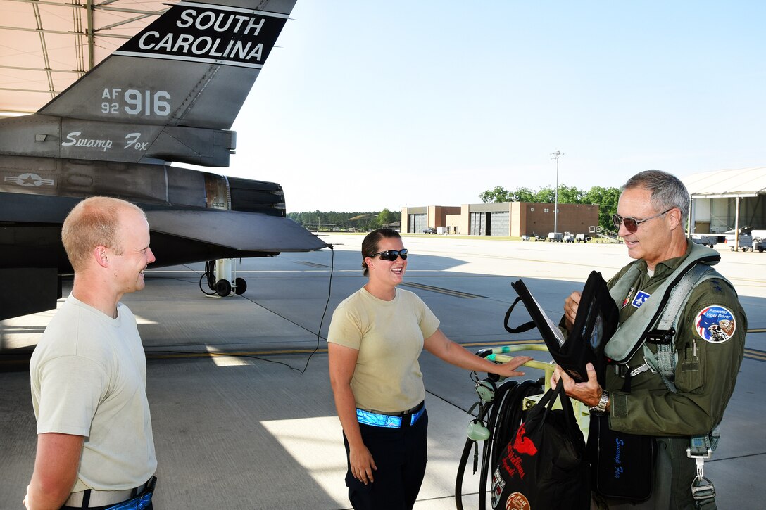 Air Force Lt. Gen. R. Scott Williams, receives an aircraft status briefing from Senior Airman Karen Griggs, center, and Tech. Sgt. Brendan Garrett at McEntire Joint National Guard Base, S.C., June 15, 2017. Williams visited the South Carolina Air National Guard to fly and train with Swamp Fox pilots assigned to the 169th Fighter Wing. Griggs and Garrett are crew chiefs assigned to the 169th Aircraft Maintenance Squadron, and Williams is commander, Continental U.S. North American Aerospace Defense Command Region. Air National Guard photo by Senior Master Sgt. Edward Snyder