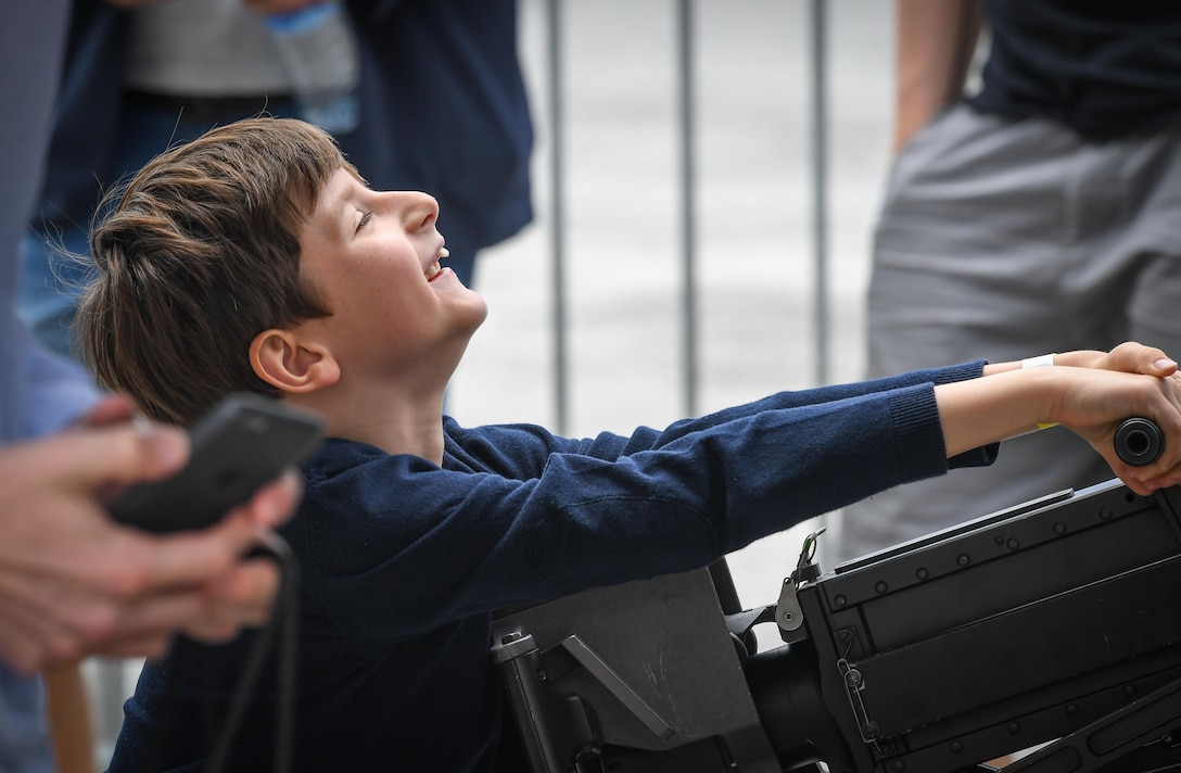 A child struggles to rack a machine gun attached to a CV-22 Osprey from Royal Air Force Mildenhall, England, at Le Bourget Airport, France, during the Paris Air Show, June 23, 2017. The Paris Air Show offers the U.S. a unique opportunity to showcase their leadership in aerospace technology to an international audience. By participating, the U.S. hopes to promote standardization and interoperability of equipment with their NATO allies and international partners. This year marks the 52nd Paris Air Show and the event features more than 100 aircraft from around the world. (U.S. Air Force photo/ Tech. Sgt. Ryan Crane)