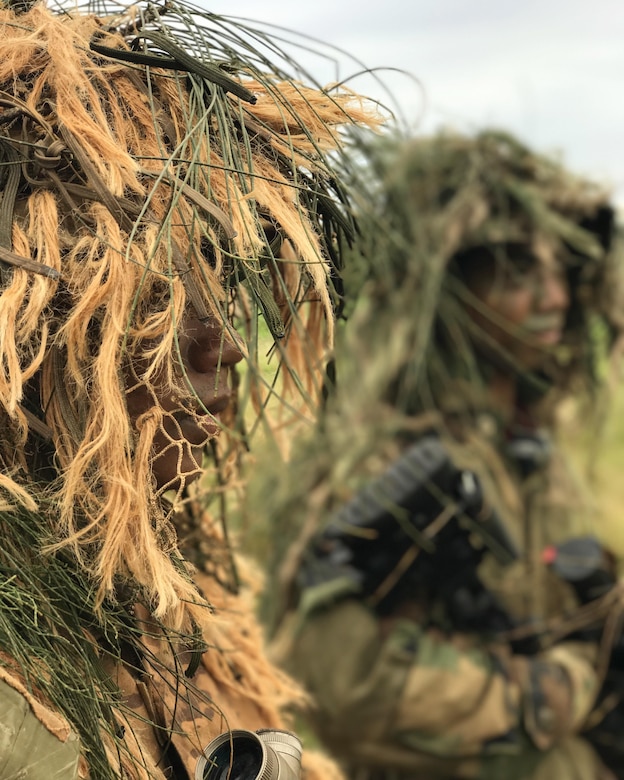 Soldiers of the 100th Battalion don Ghillie suits, June 18, 2017, in preparation for their mock ambush on opposing forces during their annual training at Kahuku Training Area.