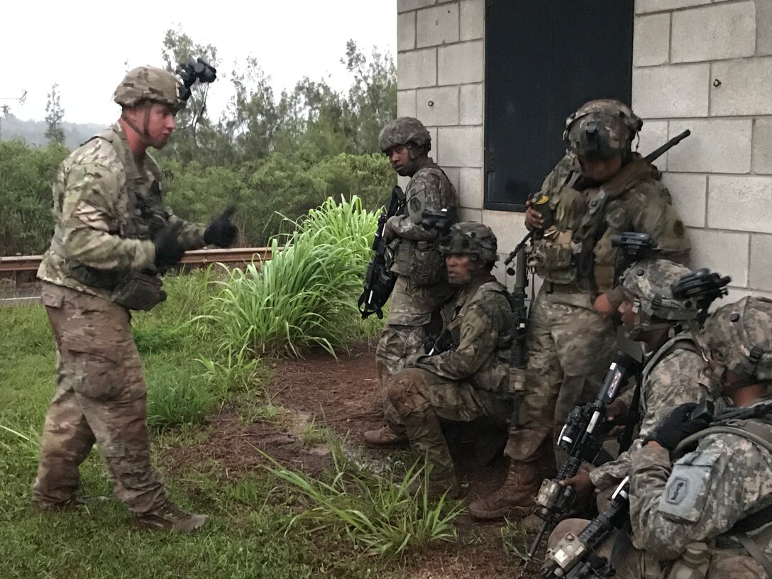 Army Reserve Soldiers of Echo Company, 100th Battalion, 442nd Infantry Regiment receive instruction from an Observer/Controller (OC) of the 196th Infantry Brigade (Training Support Brigade) during exercise Lava Forge, at Kahuku Training Area, Hawaii.
