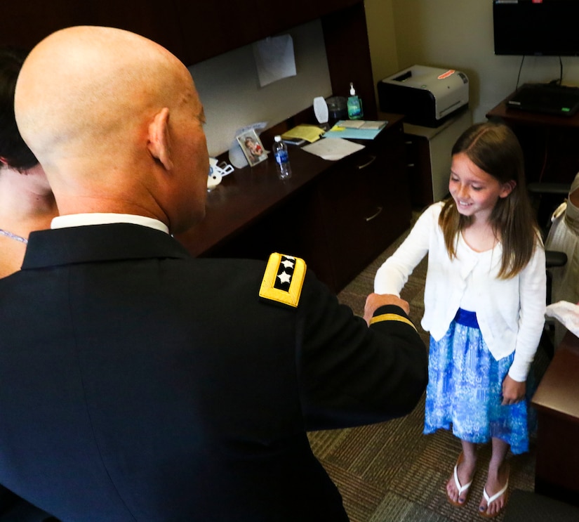Lt. Gen. Charles D. Luckey, Chief of Army Reserve and Commanding General, United States Army Reserve, thanks Haley McMahon, Maj. Gen. David Conboy’s granddaughter, with a fist bump for a drawing she gave him prior to Conboy’s retirement ceremony at Fort Bragg, NC, June 23, 2017. The  CG stated that Conboy was instrumental in providing him with a candid and complete view of where the Army Reserve currently is and where it needs to go. (U.S. Army photo by Staff Sgt. Felix R. Fimbres)