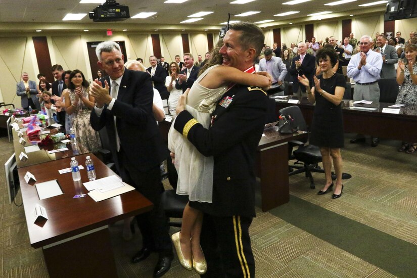 Maj. Gen. David Conboy, U.S. Army Reserve Command Deputy Commanding General, Operations, hugs his daughter after her performance during his retirement ceremony at Fort Bragg, NC, June 23, 2017. The ceremony honored Conboy for his impact on not only the U.S. Army Reserve, but the nation and its allies as well. (U.S. Army photo by Staff Sgt. Felix R. Fimbres)