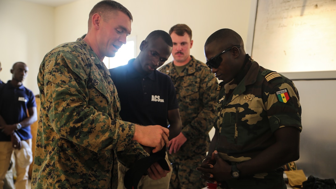 1st. Lt David Beltz, theater security cooperation Senegal team leader, presents a gift to Maj. Mamadou Sarr, base commander of Centre D’Entrainement Tactique Number 7, during the closing ceremony of a peacekeeping operations training mission at Thies, Senegal, June 16, 2017. Marines and Sailors with SPMAGTF-CR-AF served as instructors and designed the training to enhance the soldiers’ abilities to successfully deploy in support of United Nations peacekeeping missions in the continent. (U.S. Marine Corps photo by Sgt. Samuel Guerra/Released)