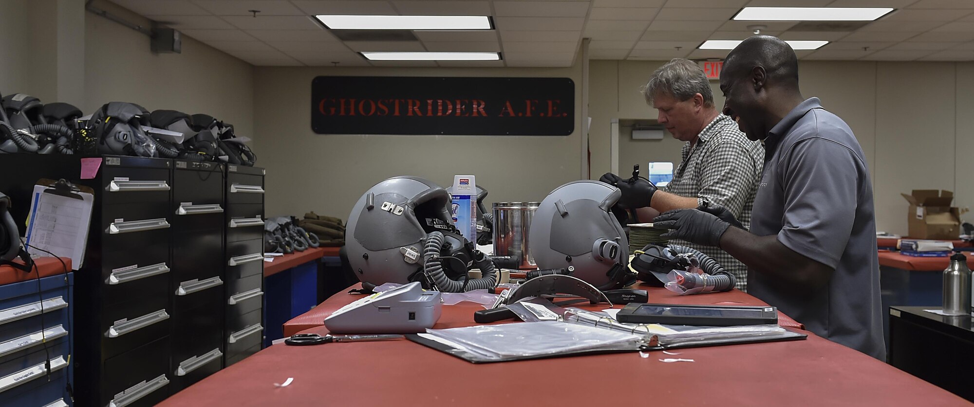 Ephraim Thomas, right, and James Vanherwaarden, aircrew flight equipment technicians with the 1st Special Operations Support Squadron, perform 30-day visual inspections on aircrew helmets at Hurlburt Field, Fla., June 15, 2017. The helmets are inspected for damages and disinfected every 30 days, while the helmets are completely broken down and rebuilt every 90 days. (U.S. Air Force photo by Airman 1st Class Rachel Yates)