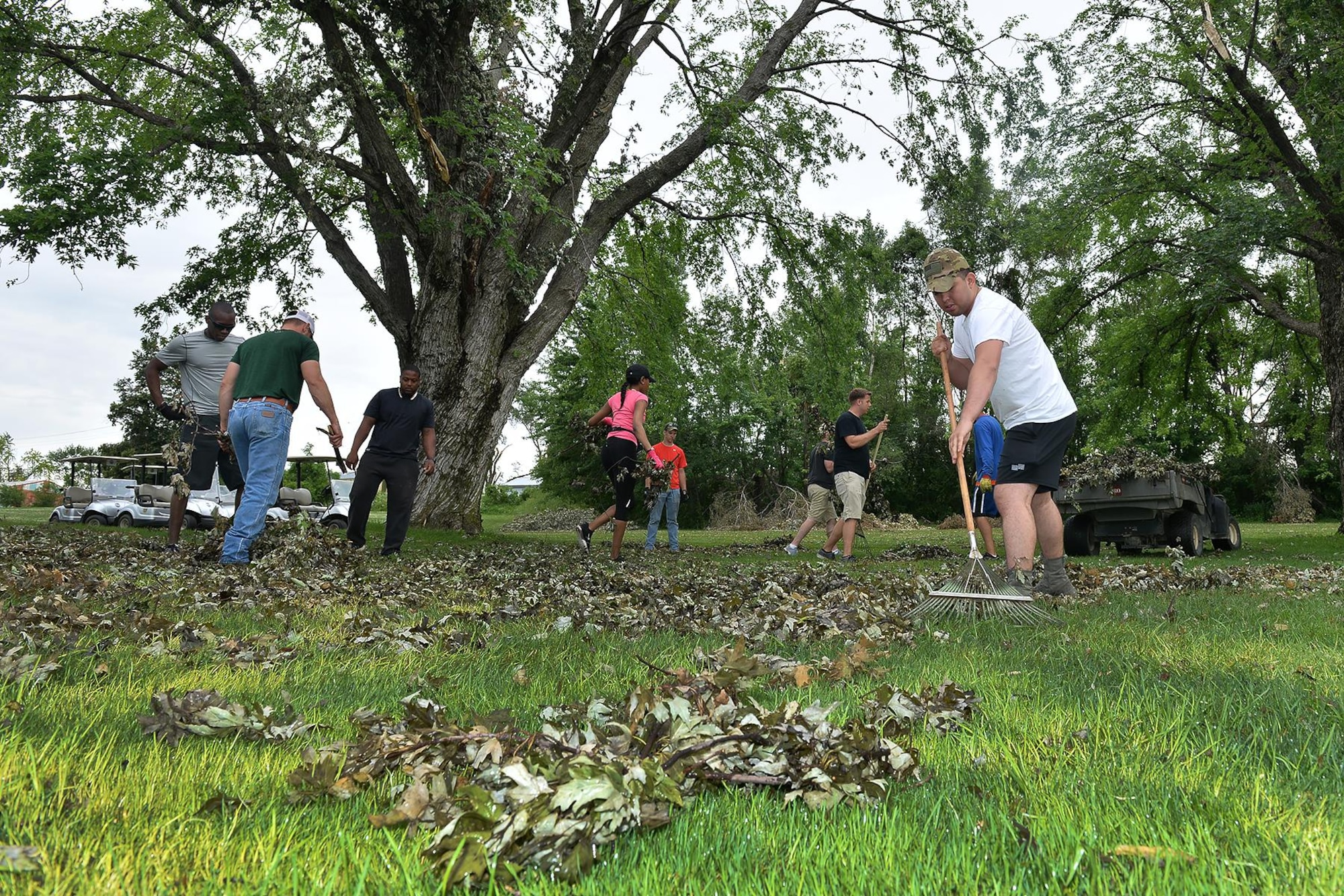 Senior Airman Abraham Rivera-Corral, 55th Communications Squadron, rakes a pile of leaves during the Willow Lake golf course cleanup on Offutt AFB, Neb., June 23. Rivera-Corral and other members of Team Offutt volunteered to help clean up the golf course following a powerful storm that hit the base June 16. The storm produced EF1 and EF2 tornadoes and caused significant damage to parts of Offutt AFB. (U.S. Air Force photo by Charles Haymond)