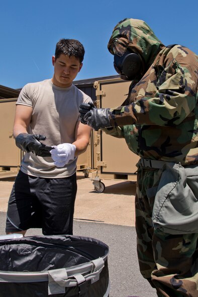 U.S. Air Force Reserve Tech. Sgt. David Underwood, (right) an aircrew flight equipment specialist assigned to the 327th Operations Support Squadron, shows Capt. Jon Leslie, copilot, 327th Airlift Squadron, how to properly remove gloves during decontamination training June 19, 2017, at Little Rock Air Force Base, Ark. Leslie just finished C-130J mission qualification training, and is a former civil engineer operations officer from Youngstown Air Reserve Station, Ohio. (U.S. Air Force photo by Master Sgt. Jeff Walston/Released)