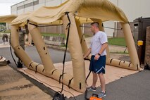 U.S. Air Force Reserve Senior Airman Joshua Pirtle (Left) and Tech. Sgt. David Underwood, aircrew flight equipment (AFE) specialists assigned to the 913th Operations Support Squadron, fill a Lightweight Inflatable Decontamination Systems (LIDS) shelter with air as part of an Aircrew Contamination Control Area (ACCA) June 19, 2017, at little Rock Air Force Base, Ark. AFE ACCA provides augmentation in support of sustained aircrew chemical defense decontamination operations to include (ACCA) and related processing capabilities for mobile operation at Forward Operating Locations. (U.S. Air Force photo by Master Sgt. Jeff Walston/Released)