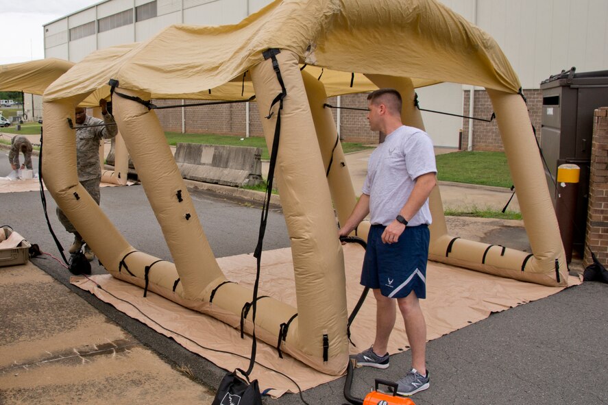 U.S. Air Force Reserve Senior Airman Joshua Pirtle (Left) and Tech. Sgt. David Underwood, aircrew flight equipment (AFE) specialists assigned to the 913th Operations Support Squadron, fill a Lightweight Inflatable Decontamination Systems (LIDS) shelter with air as part of an Aircrew Contamination Control Area (ACCA) June 19, 2017, at little Rock Air Force Base, Ark. AFE ACCA provides augmentation in support of sustained aircrew chemical defense decontamination operations to include (ACCA) and related processing capabilities for mobile operation at Forward Operating Locations. (U.S. Air Force photo by Master Sgt. Jeff Walston/Released)