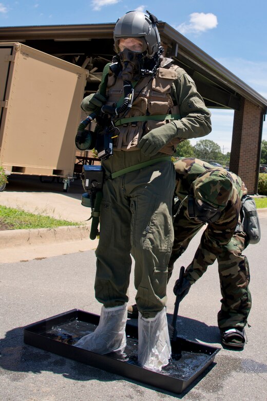 U.S. Air Force Reserve Staff Sgt. Michael Richardson, aircrew flight equipment (AFE) specialist, 913th Operations Support Squadron, scrubs down the boots of Staff Sgt. Michael Hopson, loadmaster, 327th Airlift Squadron, to remove simulated contaminants at Station #1 of the Aircrew Contamination Control Area (ACCA) June 19, 2017, at Little Rock Air Force Base, Ark. AFE specialists constructed the ACCA for training to remove simulated contaminants from aircrew members such as micro-organisms, hazardous materials or radioactive substances. (U.S. Air Force photo by Master Sgt. Jeff Walston/Released)
