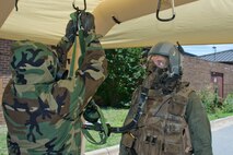 U.S. Air Force Reserve Senior Airman Joshua Pirtle, aircrew flight equipment (AFE) specialist, 327th Operations Support Squadron, hangs a manifold/blower and intercom unit in a Lightweight Inflatable Decontamination Systems (LIDS) shelter for Staff Sgt. Michael Hopson, loadmaster, 327th Airlift Squadron, during decontamination training June 19, 2017, at little Rock Air Force Base, Ark. The Aircrew Contamination Control Area (ACCA) where the training scenario took place provides augmentation in support of sustained aircrew chemical defense decontamination operations to include (ACCA) and related processing capabilities for mobile operation at Forward Operating Locations. (U.S. Air Force photo by Master Sgt. Jeff Walston/Released)