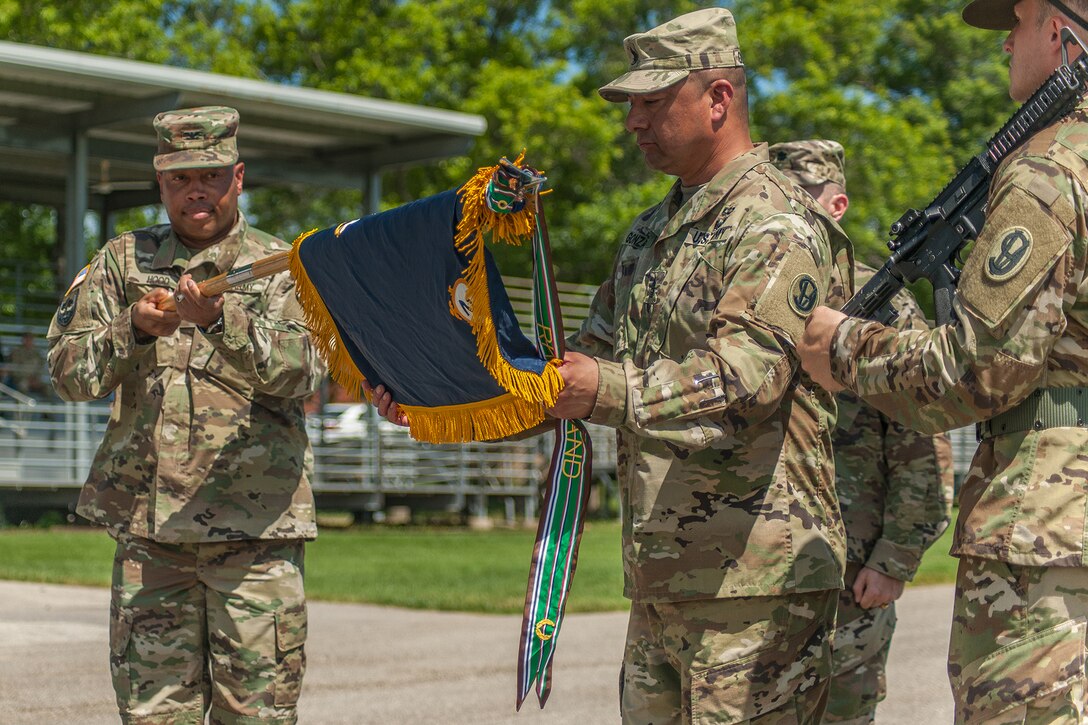 Col. Daryl Hood, 3rd Chemical Brigade commander, left, holds the guidon while Command Sgt. Maj. Jerry Gonzales unfurls the colors for the 2nd Battalion, 48th Infantry Regiment during the battalion activation ceremony Friday. The battalion was activated to support an increase to the installation's Basic Combat Training mission. 

(Photo Credit: Mr. Stephen Standifird (Leonard Wood)