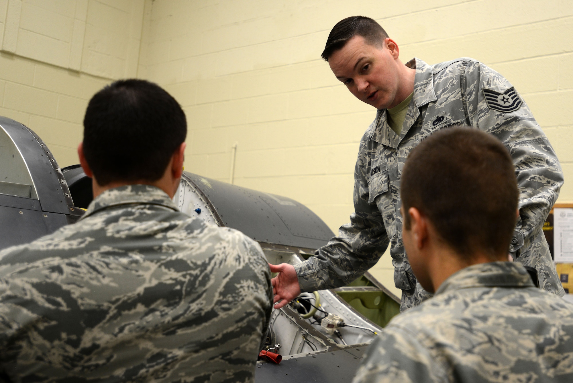 U.S. Air Force Tech. Sgt. Christopher Watson, 372nd Training Squadron, Detachment 202 F-16 armament systems instructor, explains the final steps of a gun hydraulic bleed and leak test to Senior Airman Brent Brocklehurst, weapons load crew member assigned to the 325th Aircraft Maintenance Squadron out of Tyndall Air Force Base, Fla., and Senior Airman Collin Reeder, weapons standardization technician assigned to the 96th Maintenance Group out of Eglin AFB, Fla., during training at the 372nd Training Squadron, Detachment 202 F-16 Field Training Detachment (FTD) at Shaw Air Force Base, S.C., April 25, 2017. Training at the FTD is not specific to F-16 aircraft; it also focuses on the maintenance of the equipment and munitions needed to keep the aircraft in the fight. (U.S. Air Force photo by Senior Airman Kelsey Tucker)