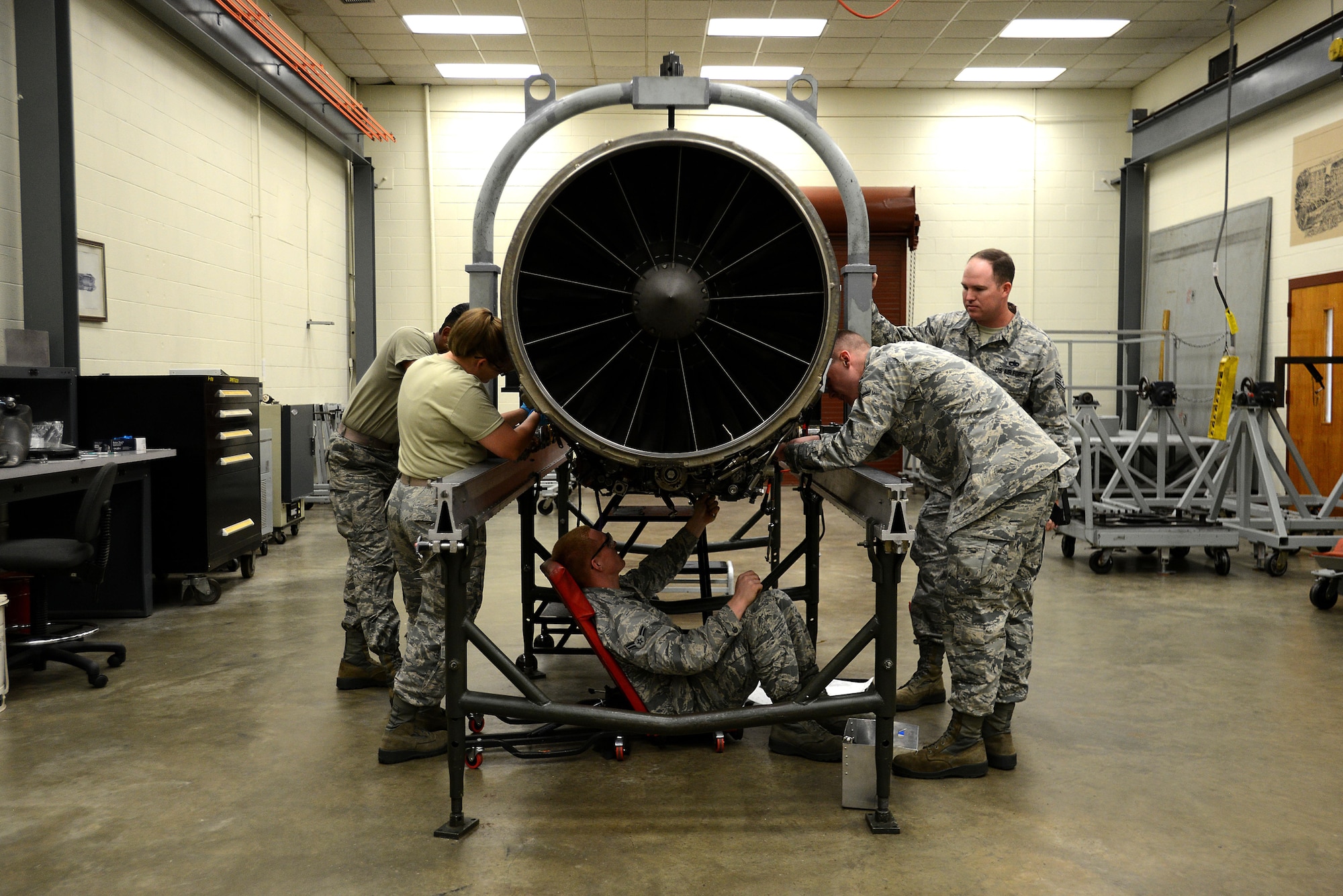 A team of four U.S. Airmen, overseen by their instructor, work together to remove the accessory drive gearbox from an F-16CM Fighting Falcon engine during training at the 372nd Training Squadron, Detachment 202 F-16 Field Training Detachment (FTD) at Shaw Air Force Base, S.C., April 25, 2017. The FTD is responsible for training not only active duty maintenance Airmen, but also Air National Guard and Air Force Reserve Airmen, and those preparing for a permanent change of station to the Pacific Air Forces area of responsibility. (U.S. Air Force photo by Senior Airman Kelsey Tucker)