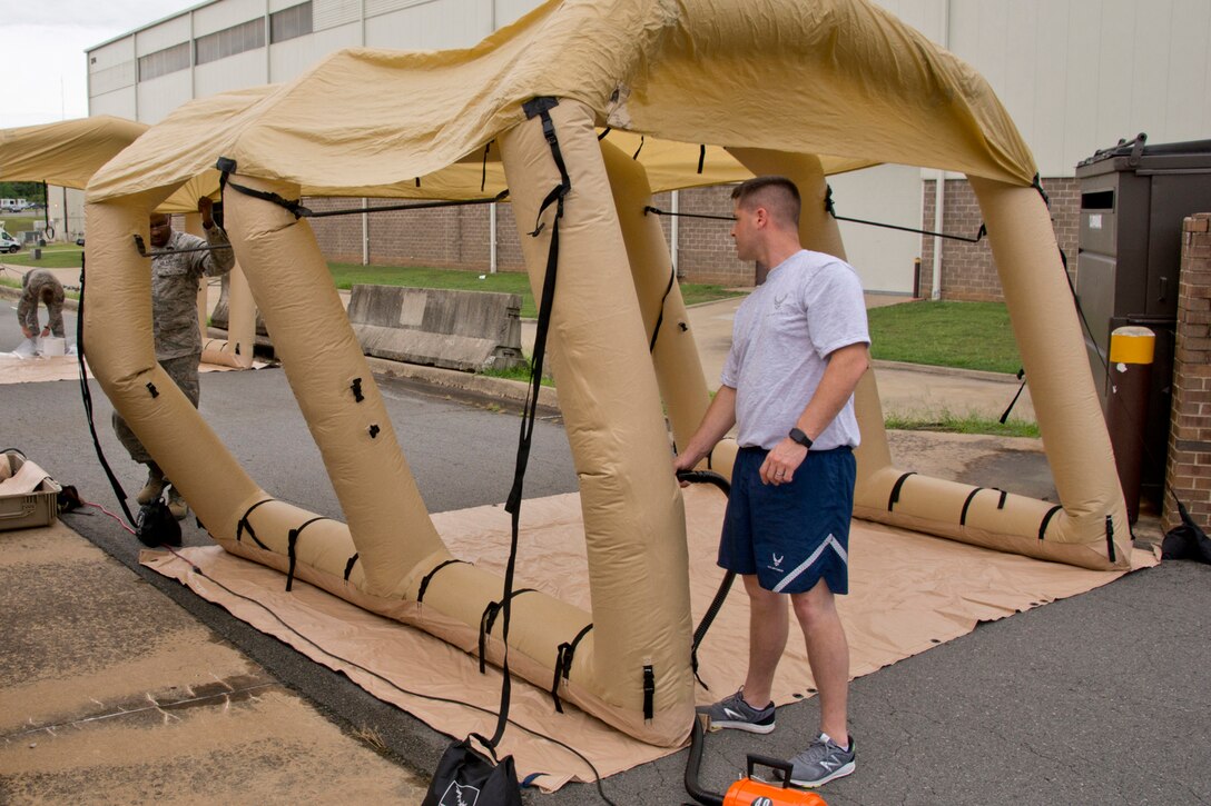 Air Force Reservists Senior Airman Joshua Pirtle, left, and Tech. Sgt. David Underwood, aircrew flight equipment specialists assigned to the 913th Operations Support Squadron, inflate a Lightweight Inflatable Decontamination Systems shelter during an aircrew contamination control area drill at little Rock Air Force Base, Ark., June 19, 2017. An ACCA provides support of sustained aircrew chemical defense decontamination operations at forward operating locations. Air Force photo by Master Sgt. Jeff Walston