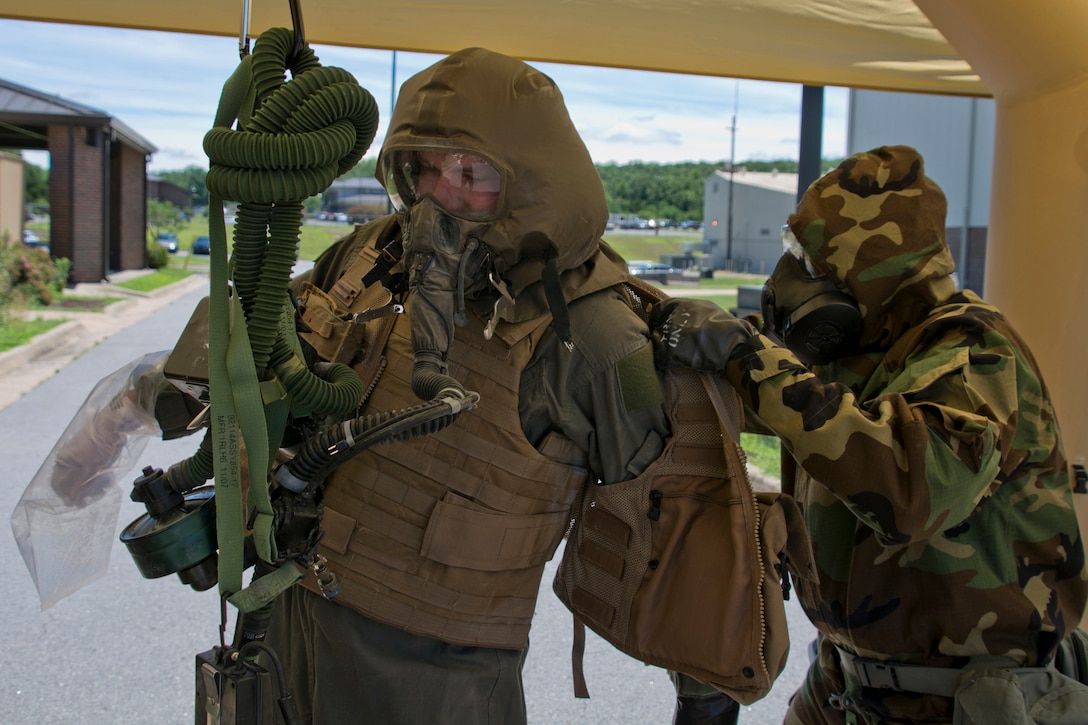 Air Force Reserve Senior Airman Joshua Pirtle, an aircrew flight equipment specialist assigned to the 913th Operations Support Squadron, removes a survival vest from Staff Sgt. Aaron Broge, a loadmaster assigned to the 327th Airlift Squadron, during decontamination training at Little Rock Air Force Base, Ark., June 19, 2017. Pirtle and three other aircrew flight equipment specialists were training to enhance skills needed to protect personnel and equipment so they can work safely and effectively in a contaminated environment. Air Force photo by Master Sgt. Jeff Walston