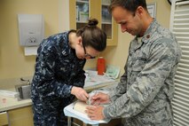 Dr. (Maj.) William Bynum (right), 11th Medical Group, advises Dr. (Lt.) Mary Beth Ray, Family Medicine Residency Program,  on how to simulate placing a hormone implant into a patient’s arm June 13, 2017 at the Fort Belvoir Community Hospital, Va. The implant is a birth control method administered to some of the adolescent and adult, a key patient population treated by the hospital's family medicine residents and faculty. (U.S. Air Force photo by Staff Sgt. Joe Yanik)