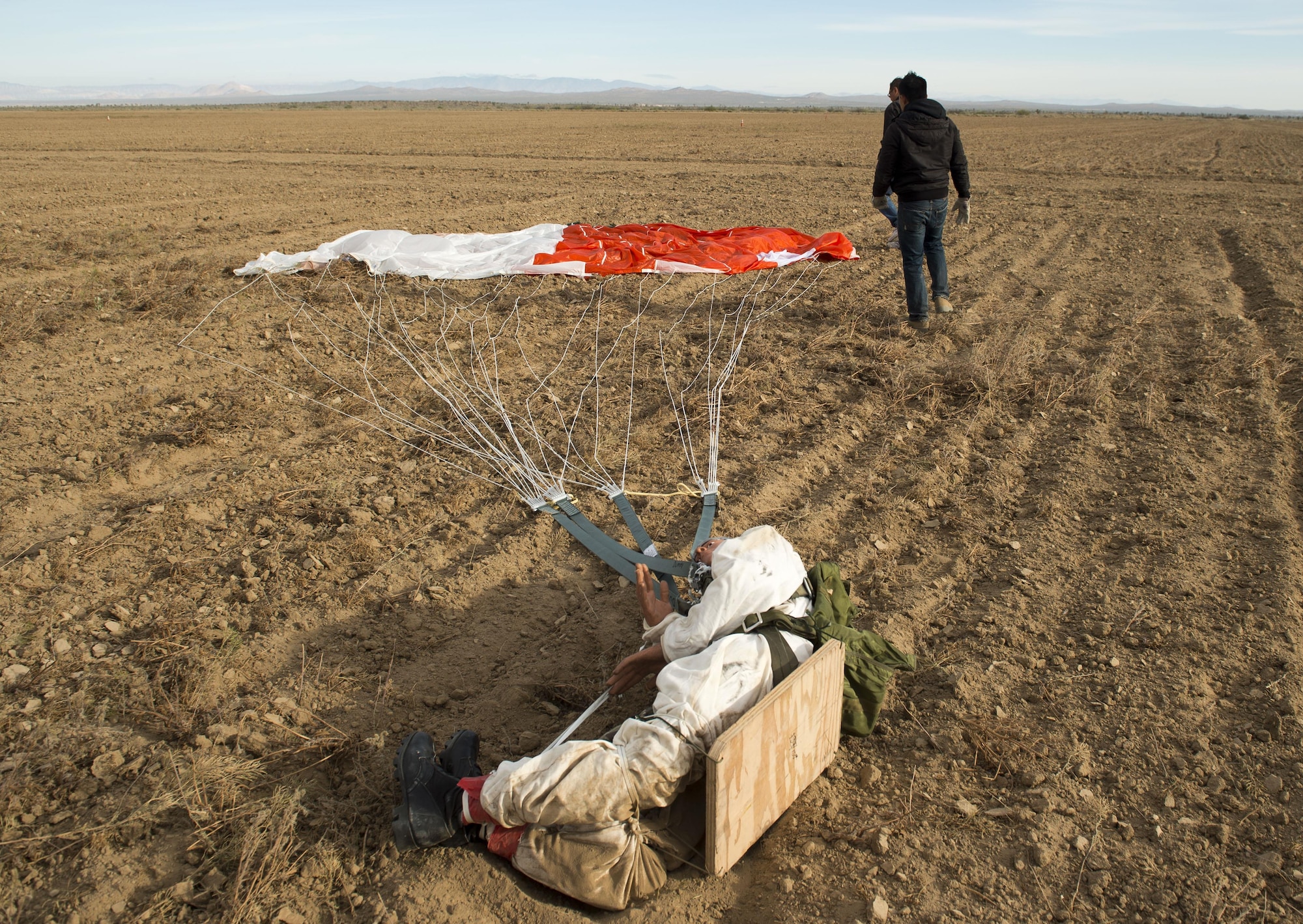 A dummy attached to a GR7000 parachute is recovered following a test drop at the ROWE drop zone south of Edwards Air Force Base. Members of the 418th Flight Test Squadron are testing a new parachute canopy for the Advanced Concept Ejection Seat II, or ACES II. (U.S. Air Force photo by Ethan Wagner)