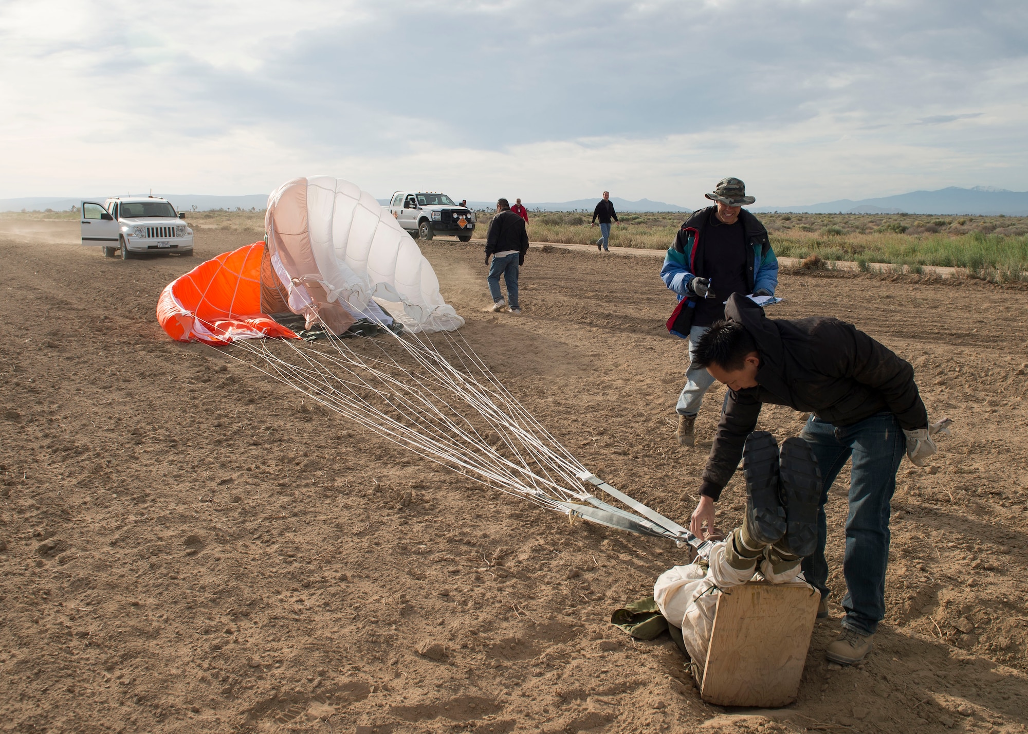 A dummy attached to a GR7000 parachute is recovered following a test drop at the ROWE drop zone south of Edwards Air Force Base. Members of the 418th Flight Test Squadron are testing a new parachute canopy for the Advanced Concept Ejection Seat II, or ACES II. (U.S. Air Force photo by Ethan Wagner)