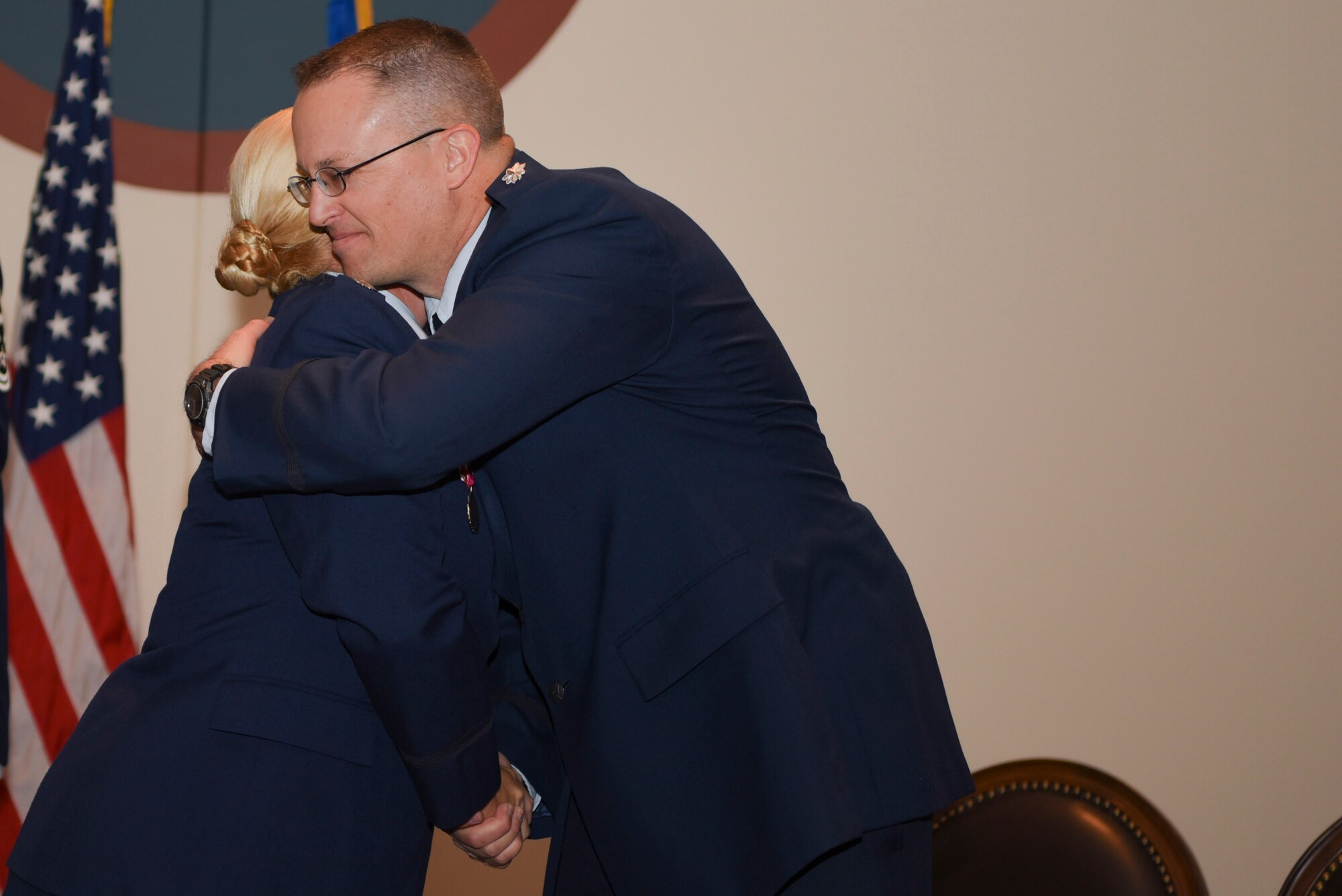 Lt. Col. Samuel Aston, 460th Logistics Readiness Squadron outgoing commander and Lt. Col. Danielle R. Kirk, 460th Logistics Readiness Squadron incoming commander share a hug after Kirk takes command June 23, 2017, on Buckley Air Force Base, Colo. Kirk is now the commander of a squadron that provides logistics support for over 6,000 personnel. (U.S. Air Force photo by Airman 1st Class Holden S. Faul/ released)