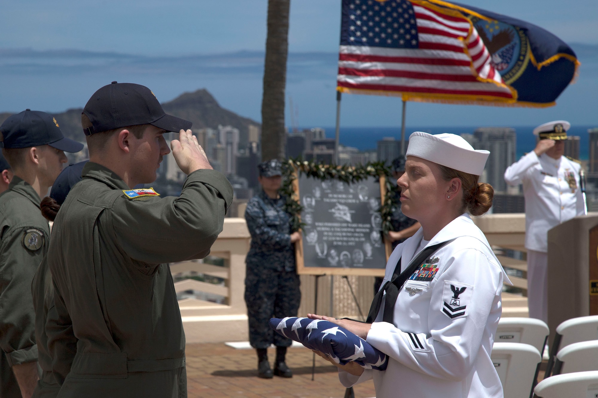 Naval Air Crewman (Mechanical) 3rd Class Douglas Lafollett, assigned to Fleet Air Reconnaissance Squadron Three, salutes the ensign during the Crew 4 memorial ceremony in Honolulu. (U.S. Navy photo by Petty Officer 1st Class Cody R. Boyd)