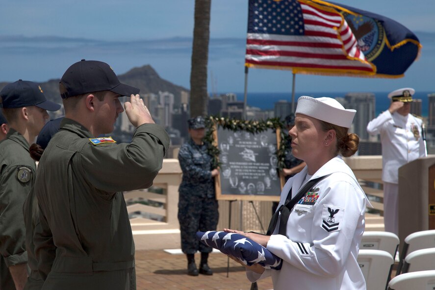 Naval Air Crewman (Mechanical) 3rd Class Douglas Lafollett, assigned to Fleet Air Reconnaissance Squadron Three, salutes the ensign during the Crew 4 memorial ceremony in Honolulu. (U.S. Navy photo by Petty Officer 1st Class Cody R. Boyd)