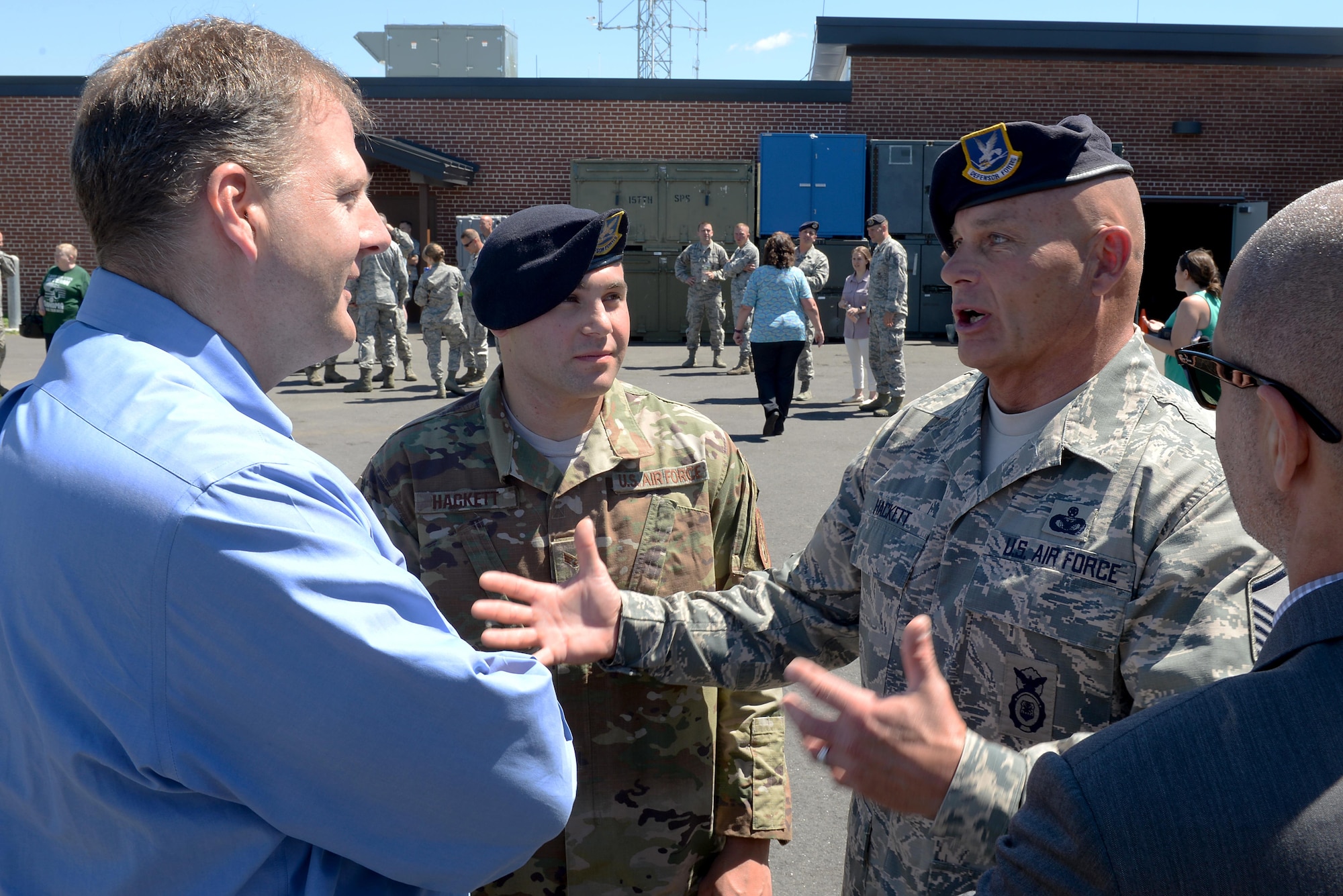 Master Sgt. Timothy J. Hackett, the traditional operations superintendent of the 157th Security Forces Squadron, and his son, Senior Airman Travis J. Hackett, of the 91st Missile Security Forces Squadron, speak with N.H. Gov. Chris T. Sununu at a deployment ceremony June 25, 2017, at Pease Air National Guard Base, N.H. Hackett is scheduled to deploy midsummer in support of Operation Freedom's Sentinel.