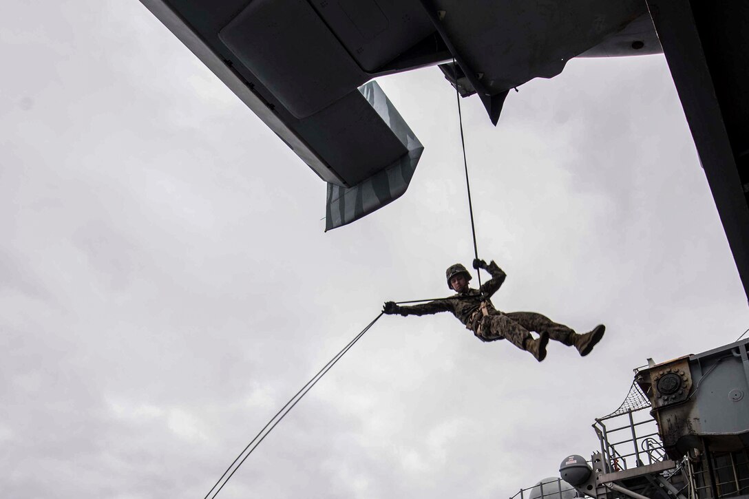 Marine Corps Lance Cpl. Will Bunch rappels from an MV-22B Osprey onto the port aircraft elevator of the amphibious assault ship USS Bonhomme Richard in the Coral Sea, June 26, 2017. The Richard is operating in the Indo-Asia-Pacific region to enhance partnerships and be a ready-response force for any type of contingency. Navy photo by Petty Officer 2nd Class Kyle Carlstrom