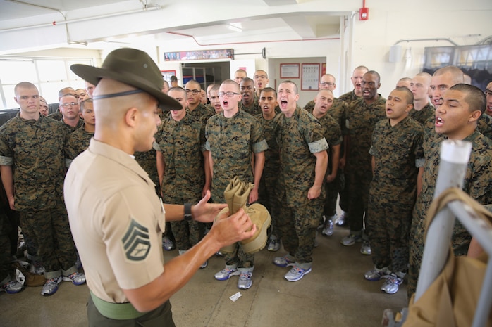 A drill instructor with Alpha Company, 1st Recruit Training Battalion, teaches recruits the difference between their two sets of combat boots during pick up at Marine Corps Recruit Depot San Diego, May 12. During the first few hours the drill instructors are with their new recruits they will teach them the in-house procedures they must follow for the rest of recruit training. Annually, more than 17,000 males recruited from the Western Recruiting Region are trained at MCRD San Diego. Alpha Company is scheduled to graduate Aug. 4.