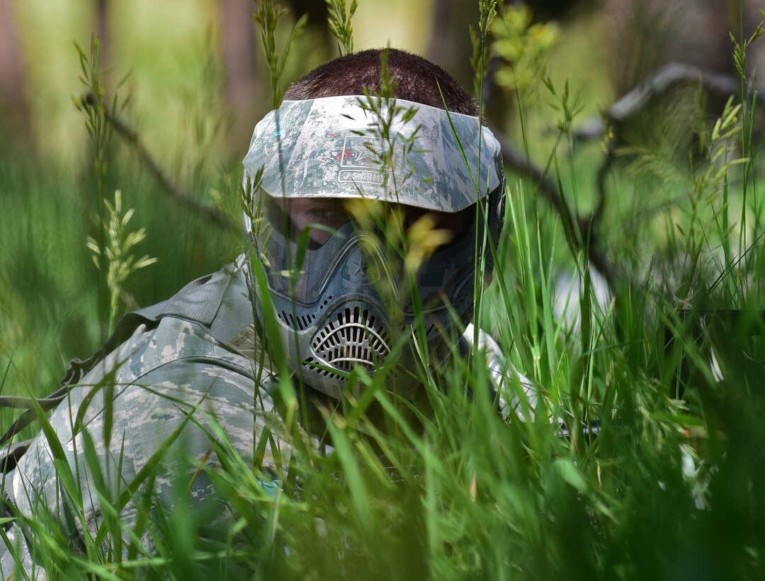 An Airman assigned to the 28th Civil Engineer Squadron uses tall grass as concealment during a U.S. Army led field training at a South Dakota National Guard training site June 19, 2017. The Airmen wore paintball masks as both sides wielded paintball guns to replicate live combat reactions. (U.S. Air Force photo by Senior Airman James L. Miller)